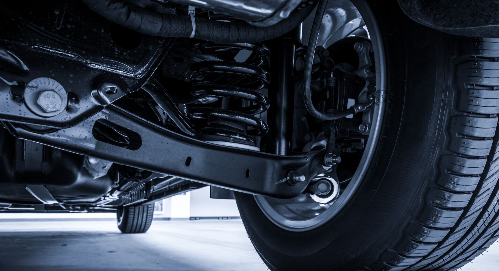 A Man Is Working On The Underside Of A Car In A Garage — Summit Smash Toongabbie In Toongabbie, NSW
