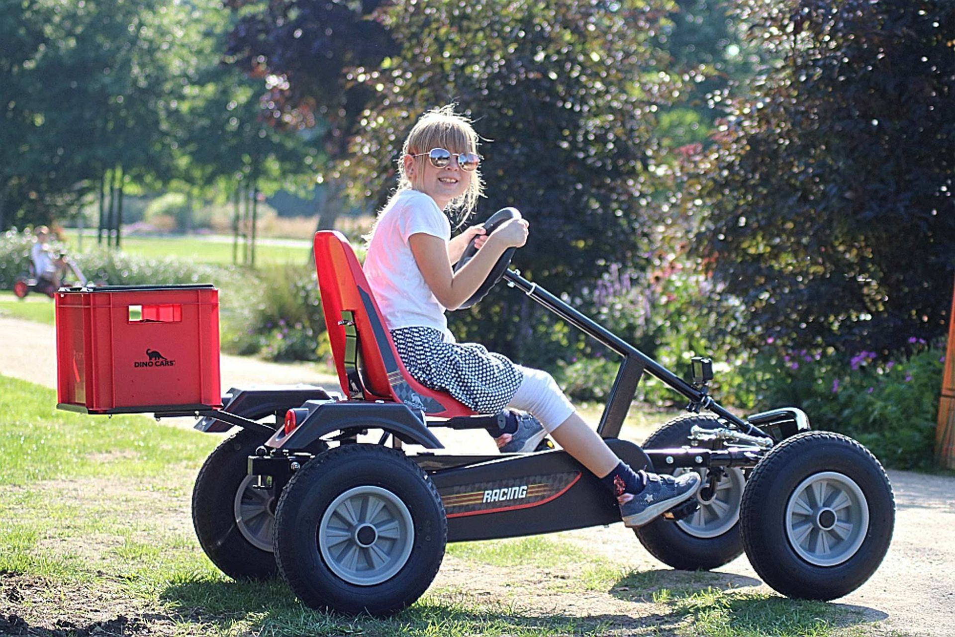 Una niña está conduciendo un kart en un parque.