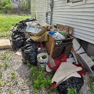 Junk and debris pile outside home before removal – St. Louis MO
