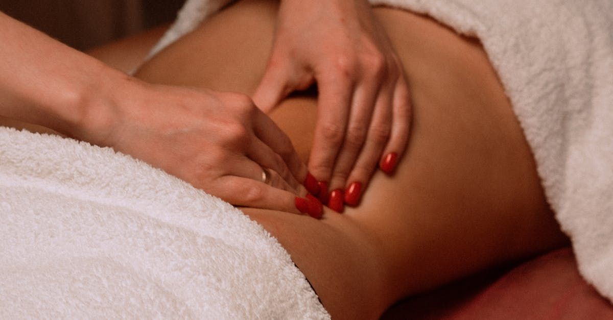 A woman with red nails is getting a massage at a spa.