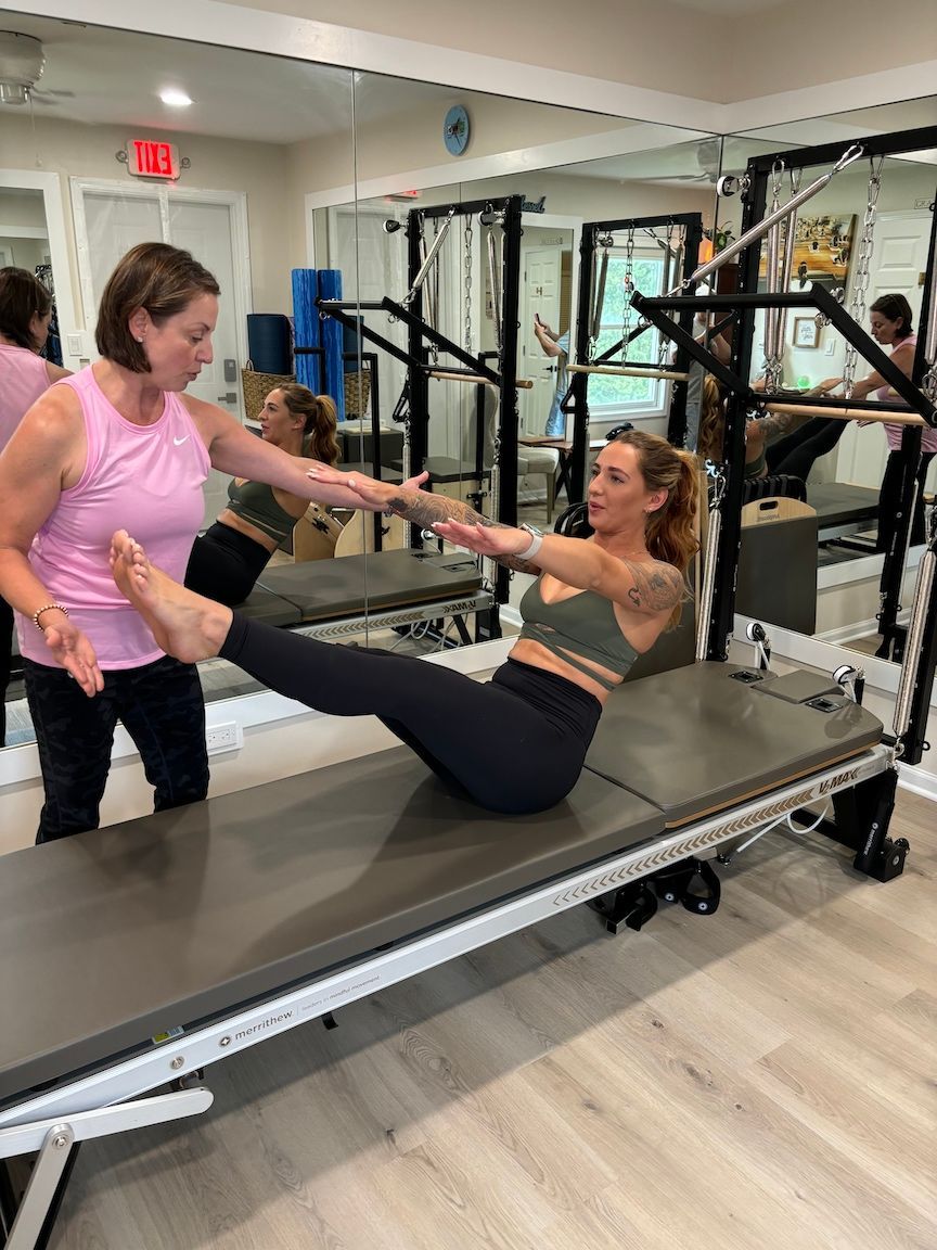 Pilates and Intuitive Energy Healing. Asha is doing pilates on a pilates machine in a gym.