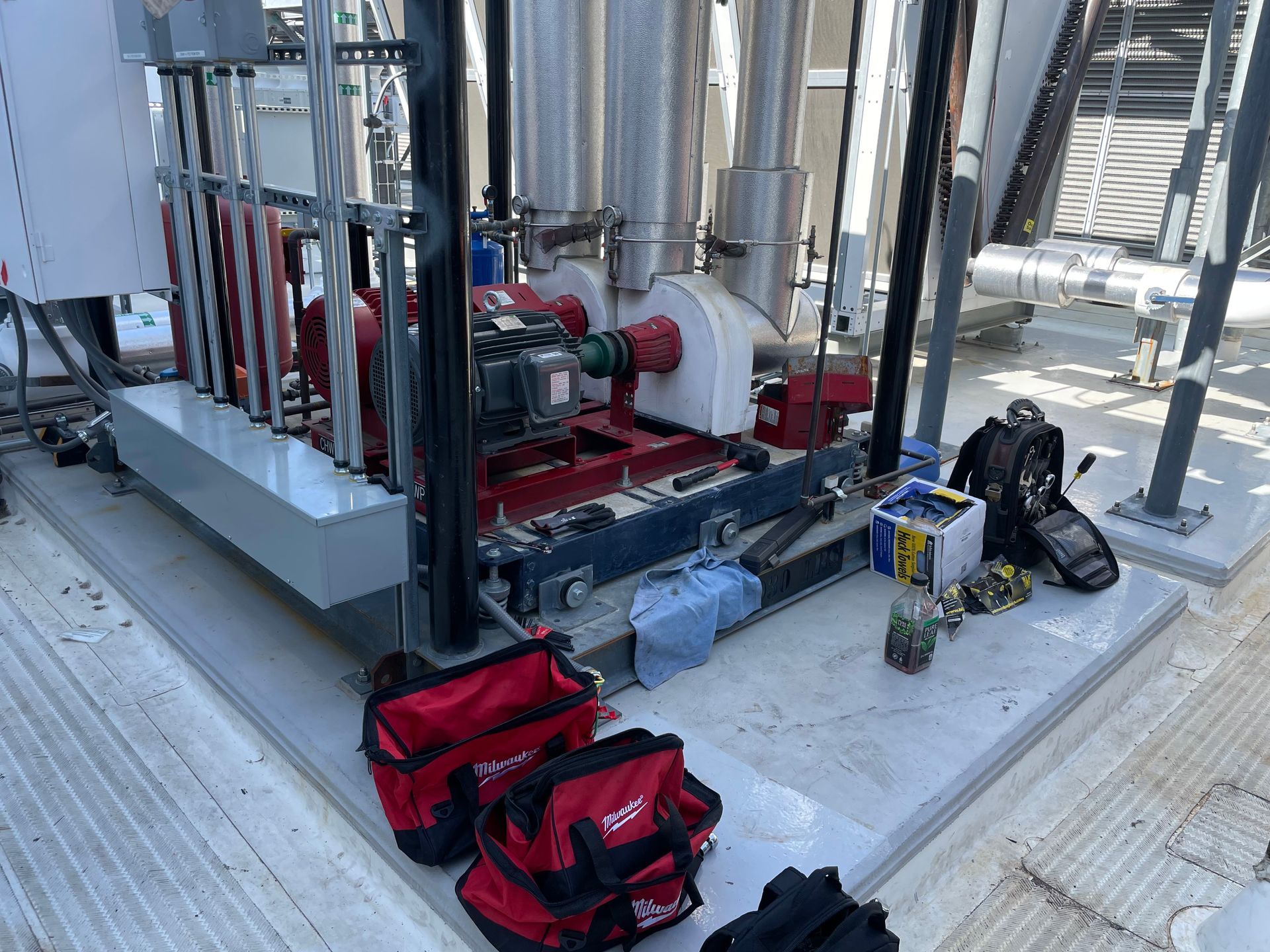 A bunch of tools are sitting on the ground next to a machine.