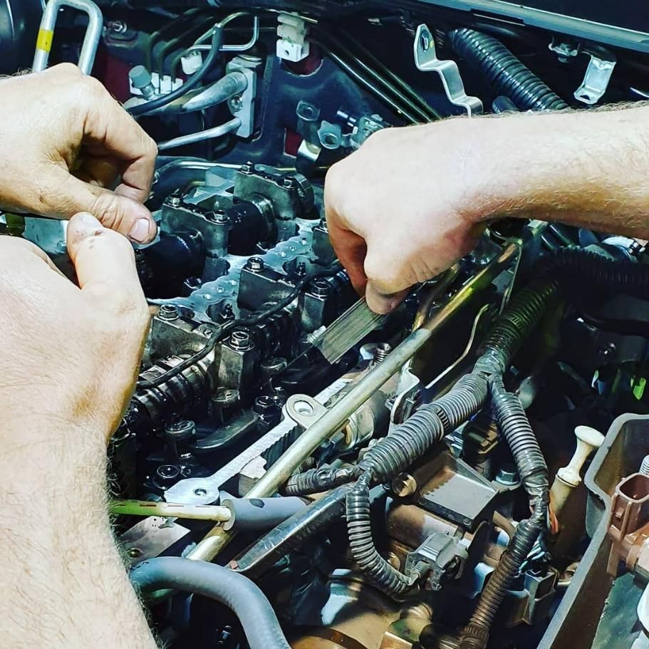 A Man Is Working on A Car Engine with A Wrench — Coalfields Mechanical & Towing in Blackwater, QLD