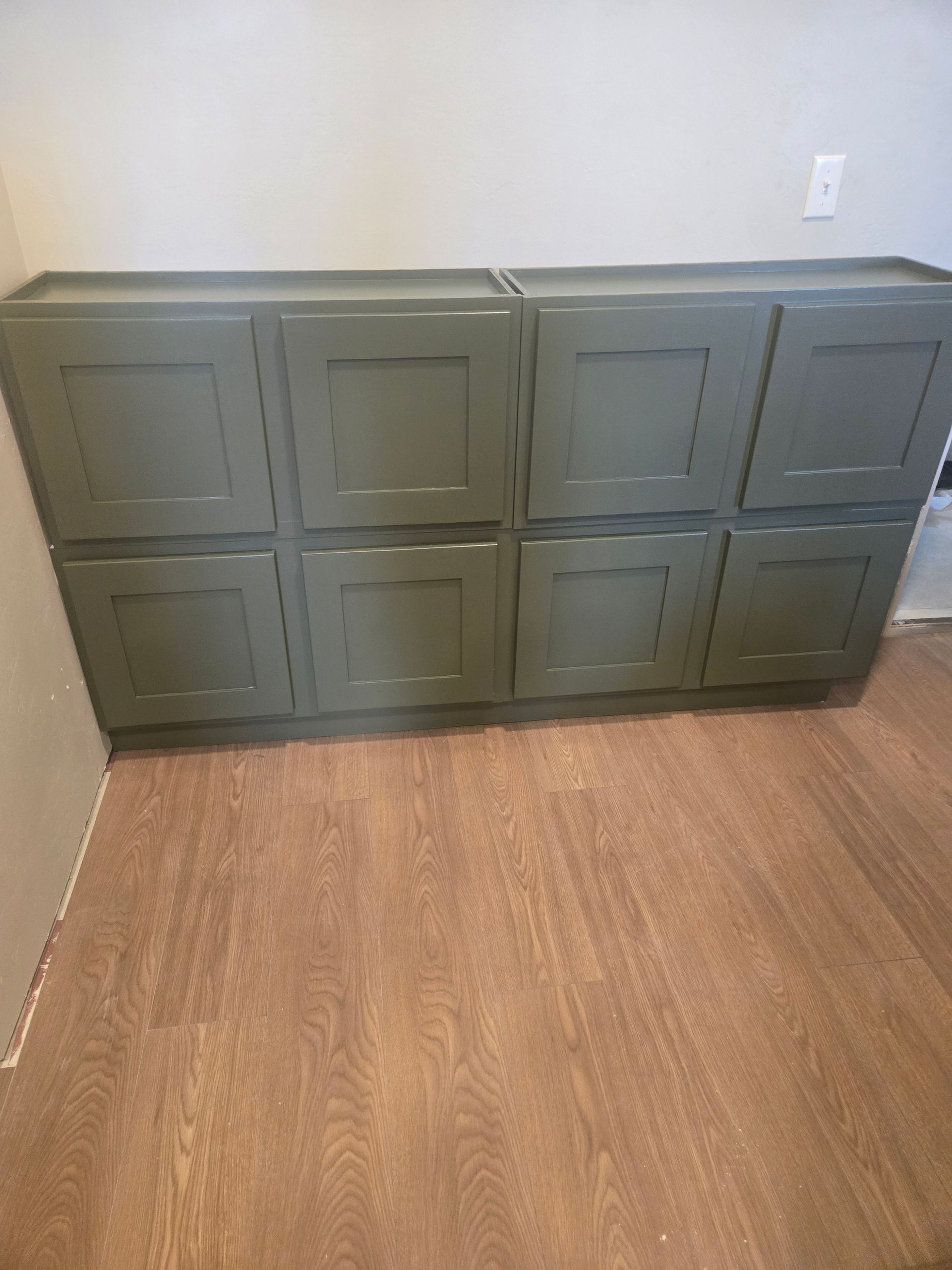 Gray storage cabinet against a white wall on a wood floor