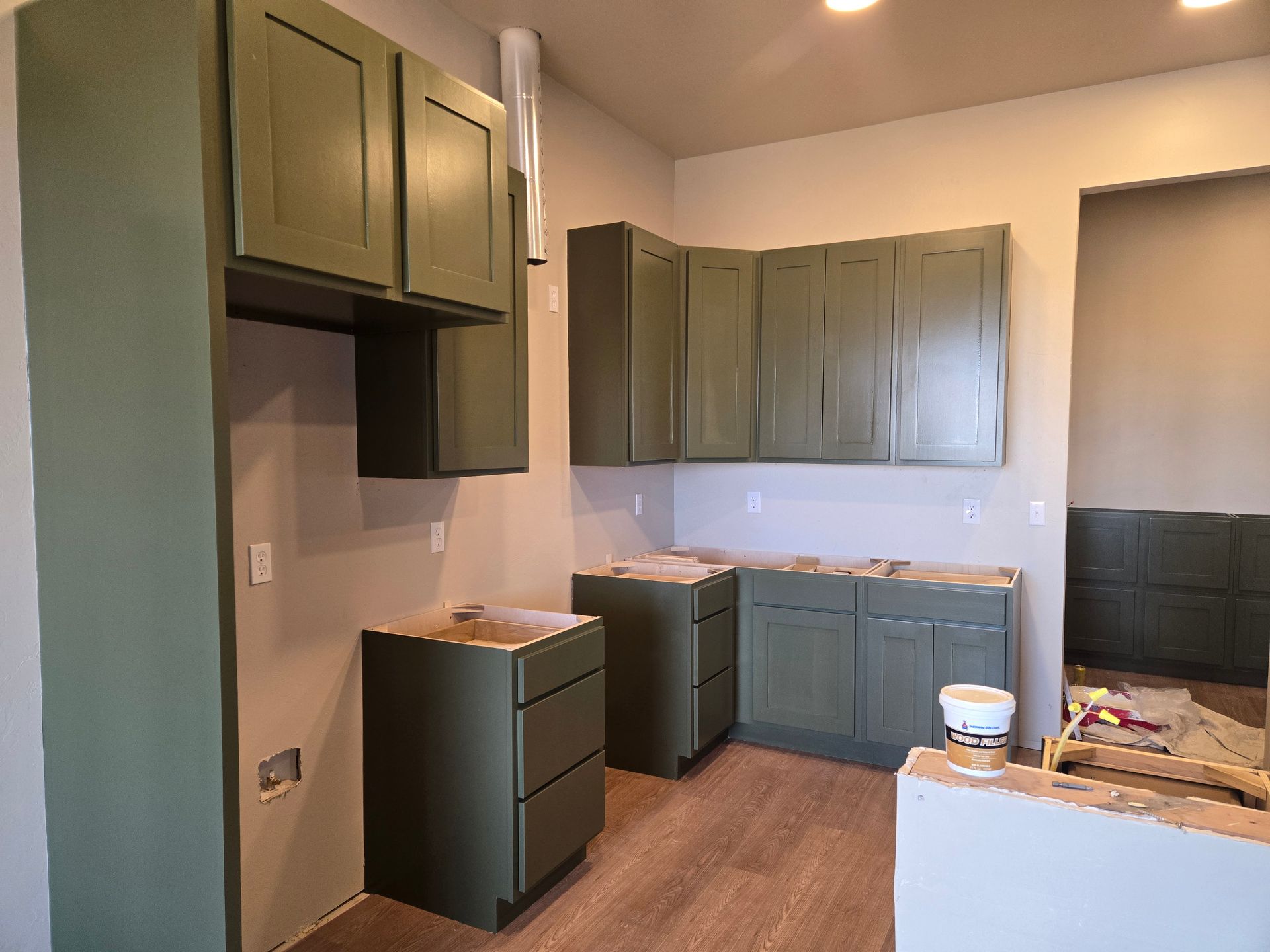 Partially renovated kitchen with gray cabinets and countertops under construction