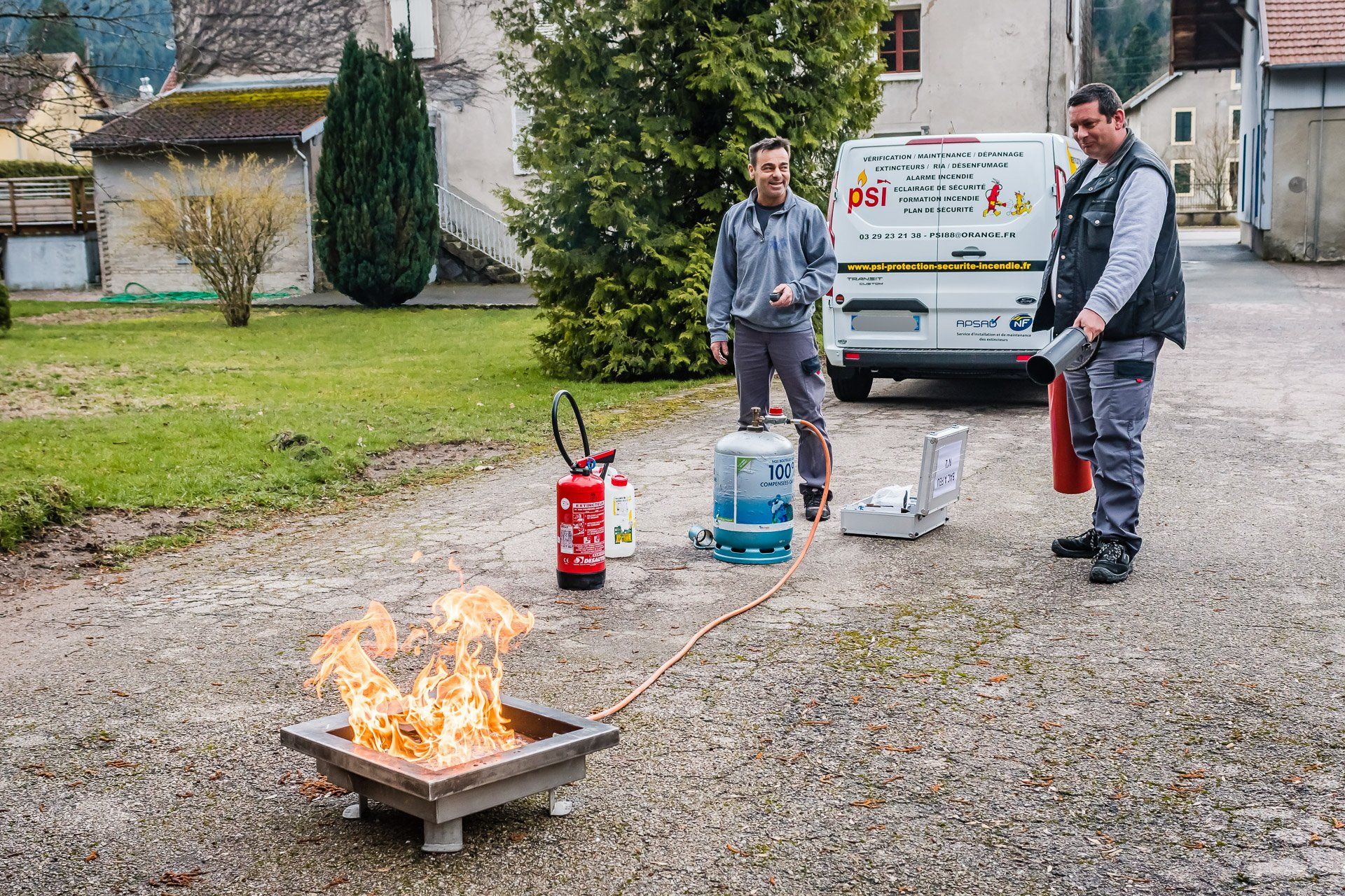 Deux hommes utilisent des extincteurs pour éteindre un incendie.