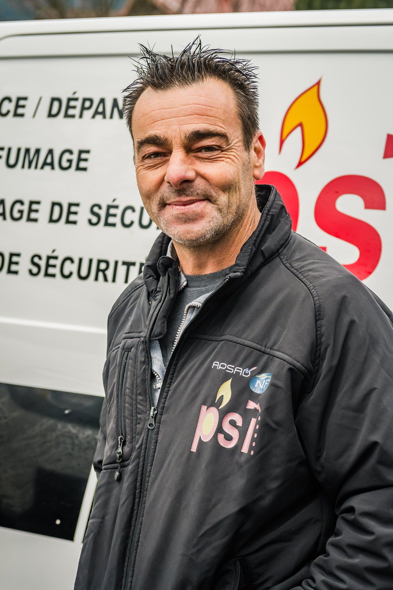 Un homme portant une veste sur laquelle est écrit psi