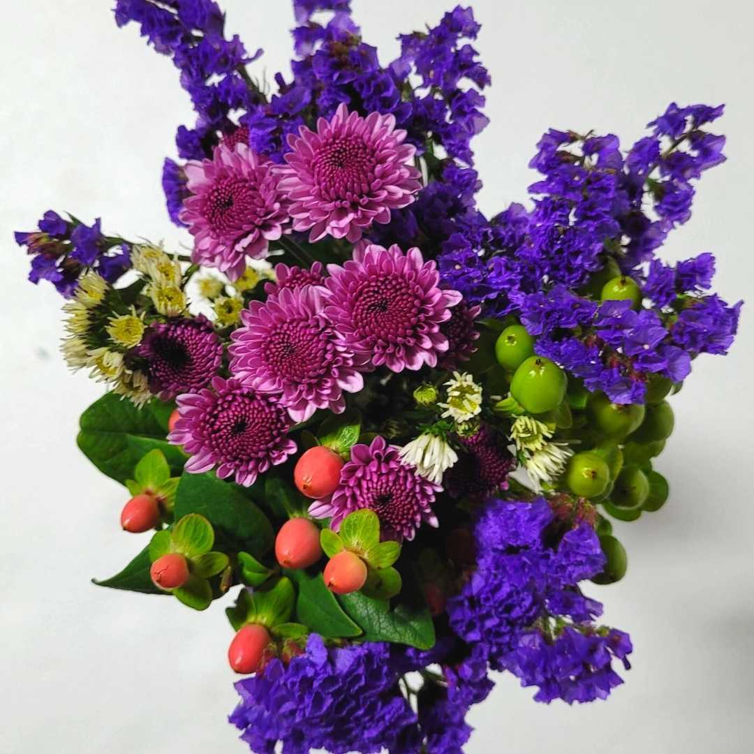 a bouquet of purple and pink flowers with green leaves