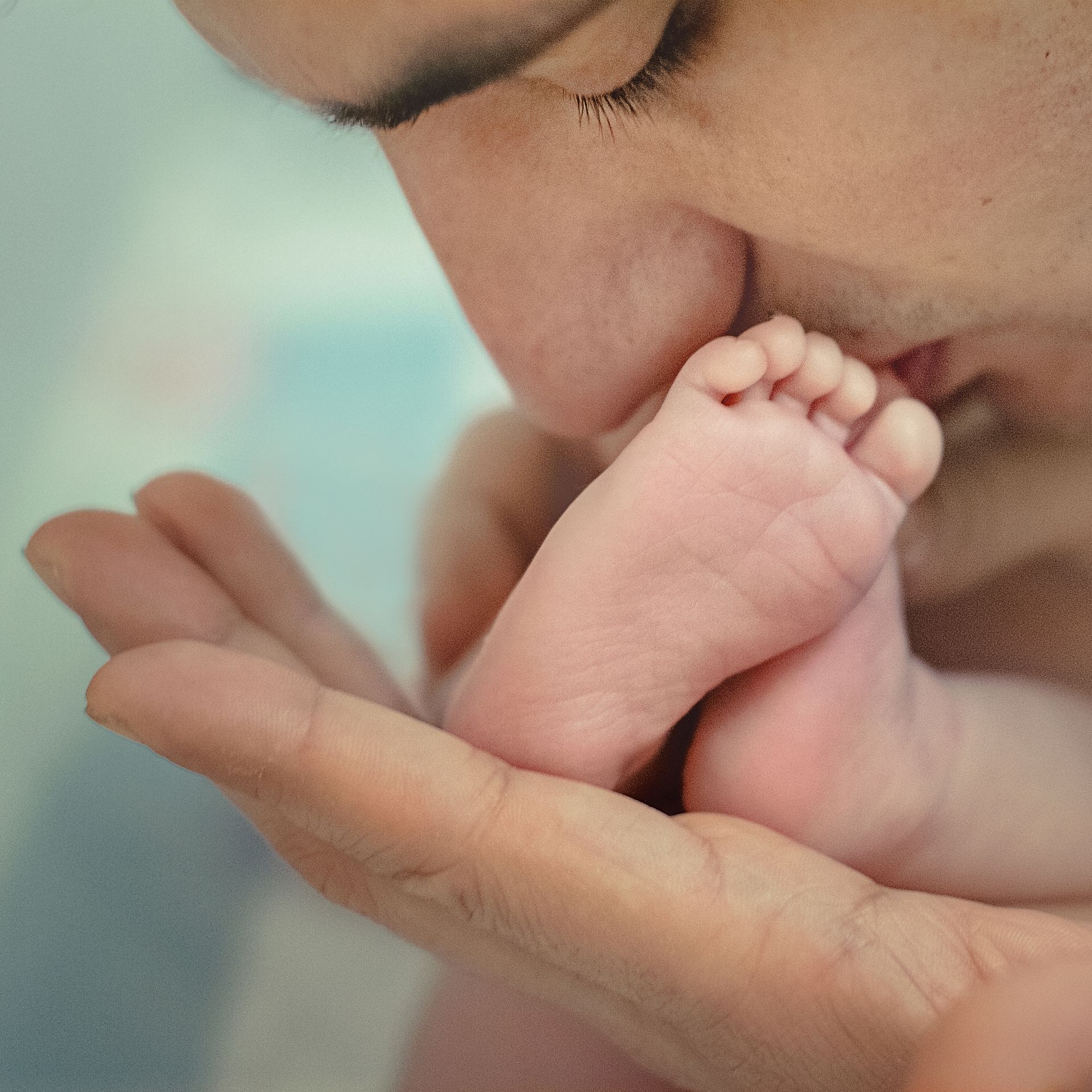 A person kissing a baby's foot, representing paternity cases in Broward County, FL.
