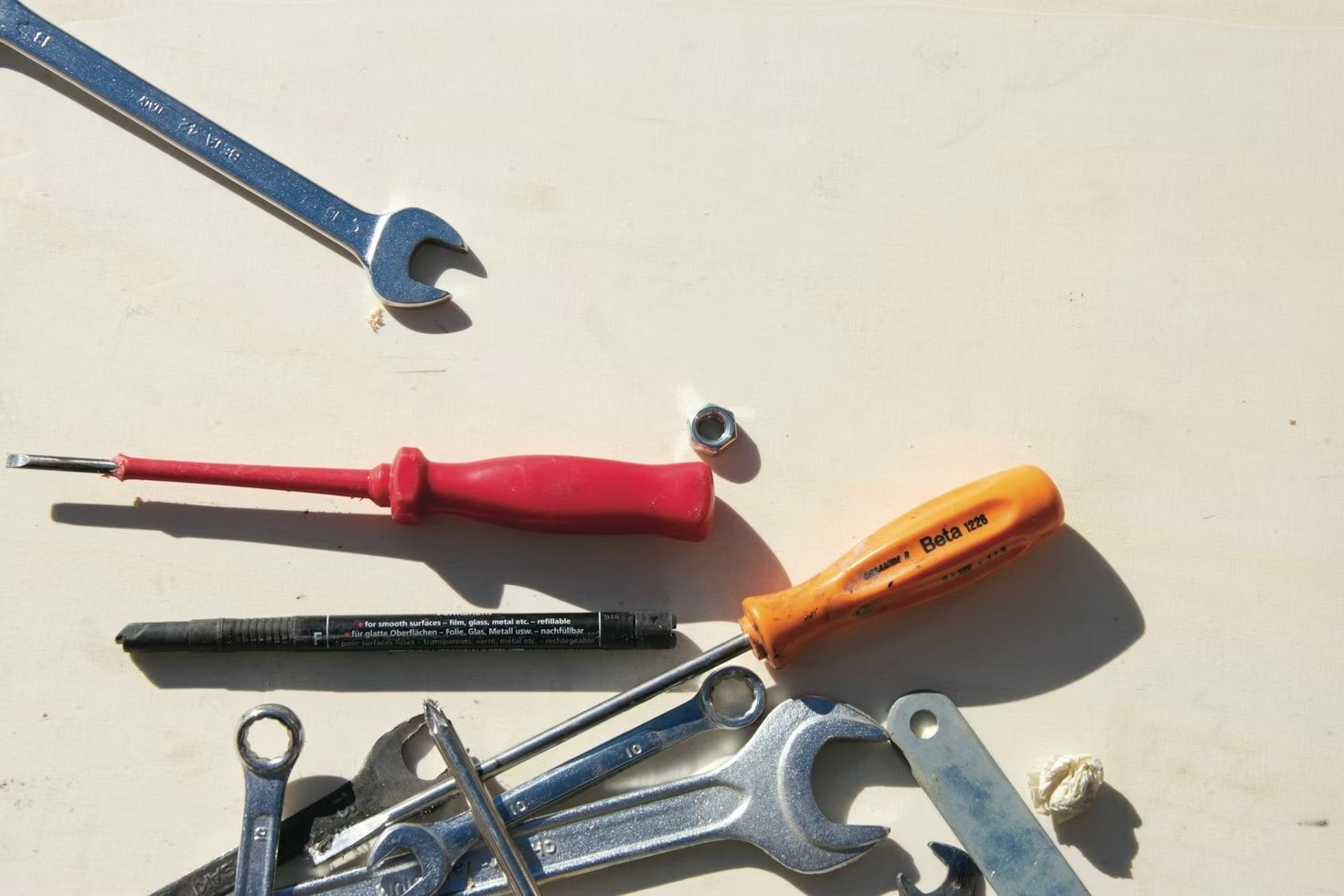 Red and black tool belt filled with various tools, with blurred figures in the background.