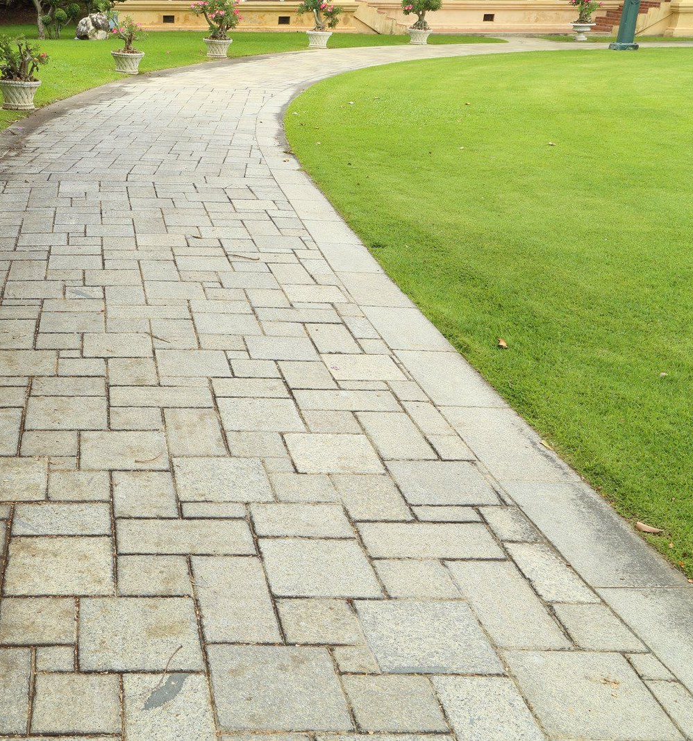 Stone walkway curves through green grass.