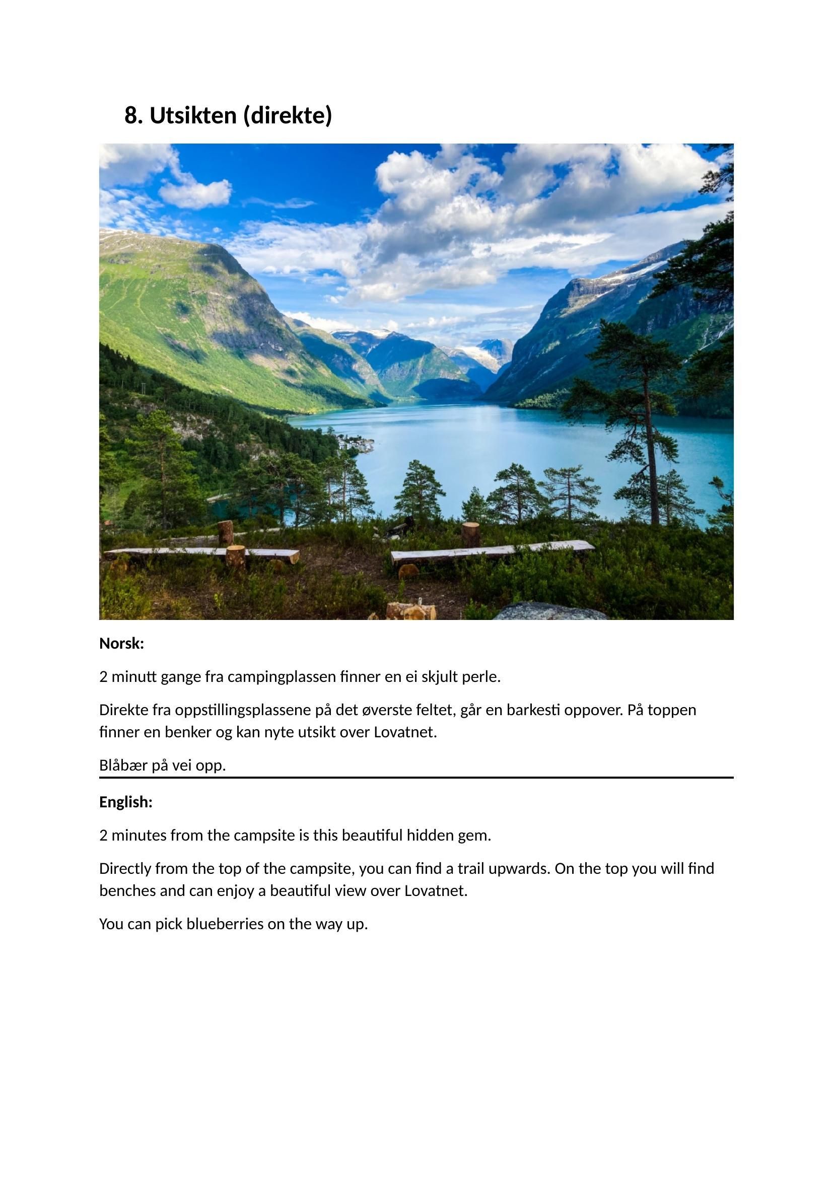 Fjellsjø med grønn dal, snødekte topper, blå himmel og skyer reflektert i rolig vann