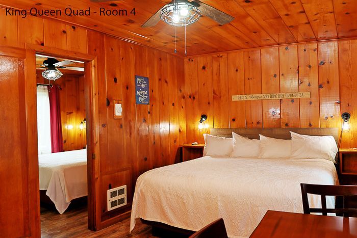 Cozy wooden bedroom with king bed, mirrored closet, and warm lighting