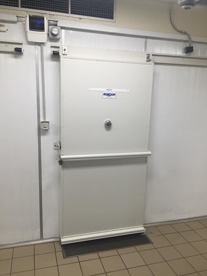 A White Door is Open in a Room With a Tiled Floor — Todd Hayes Refrigeration & Air Conditioning Pty Ltd in Kyogle, NSW