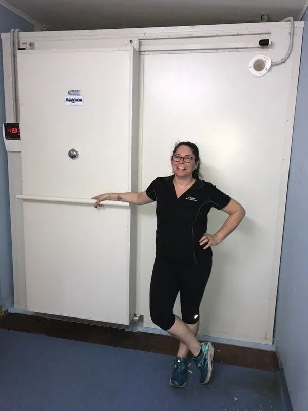 A Woman is Standing in Front of a Sliding Door in a Room — Todd Hayes Refrigeration & Air Conditioning Pty Ltd in Kyogle, NSW