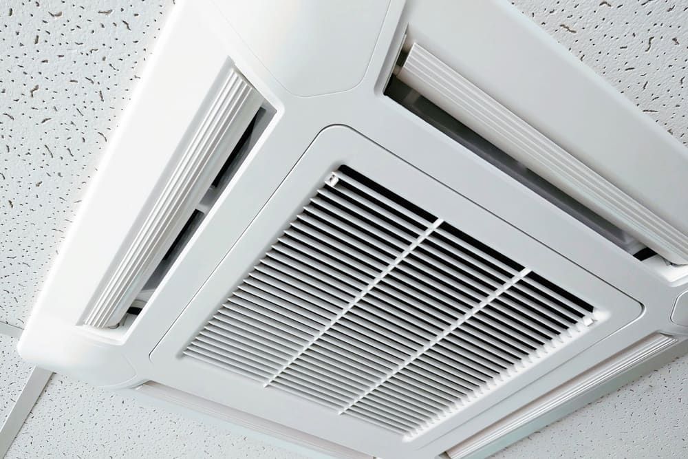 A White Air Conditioner is Mounted to the Ceiling of a Room — Todd Hayes Refrigeration & Air Conditioning Pty Ltd in Kyogle, NSW