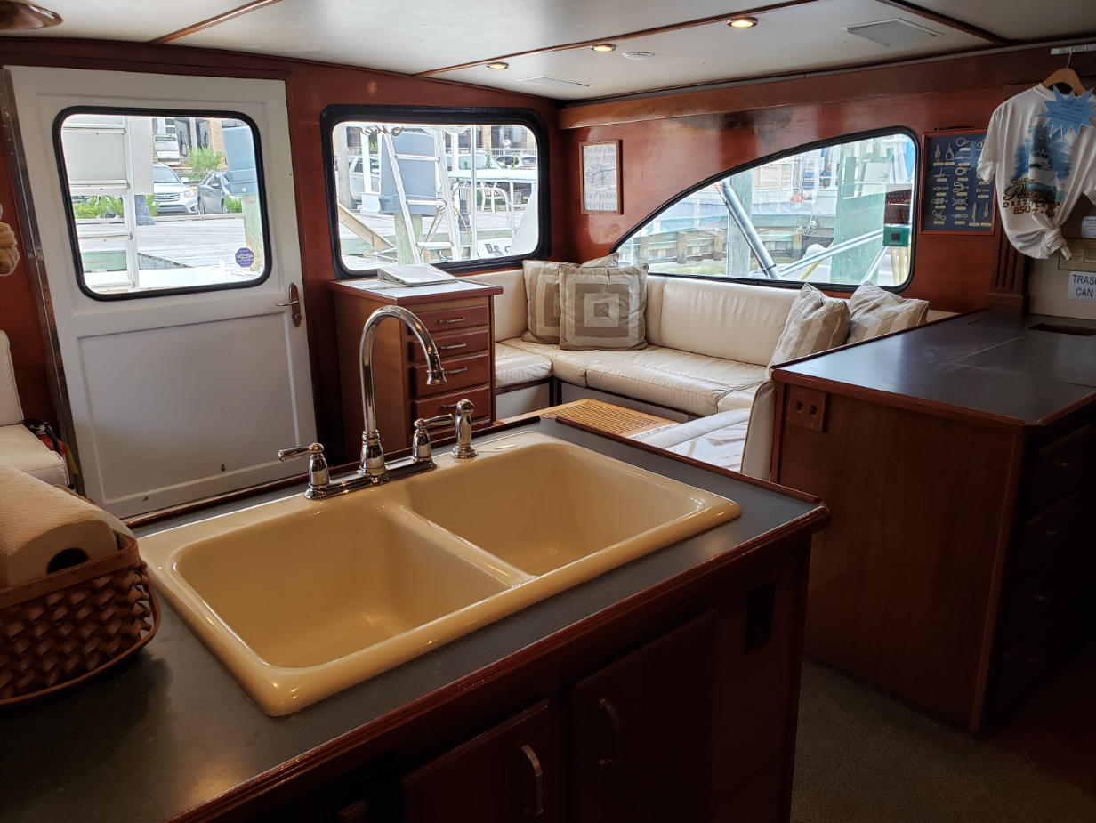 Fishing Destin, FL | Destin Harbor | Charter Boat Relentless | www.charterboatrelentless.com | A Luxury Charter Boat at Everyday Rates | 65' x 20' | A kitchen with a sink and a couch in the background.