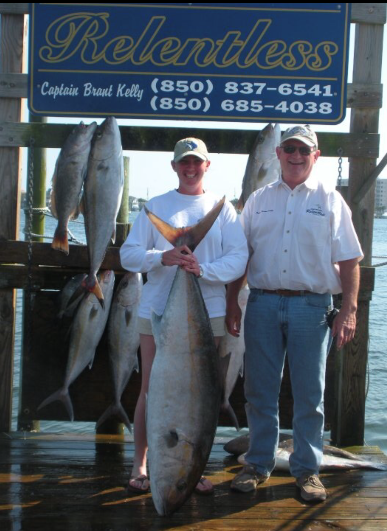Fishing Destin, FL | Destin Harbor | Charter Boat Relentless | www.charterboatrelentless.com | A Luxury Charter Boat at Everyday Rates | 65' x 20' | Two men holding large fish in front of a Relentless sign