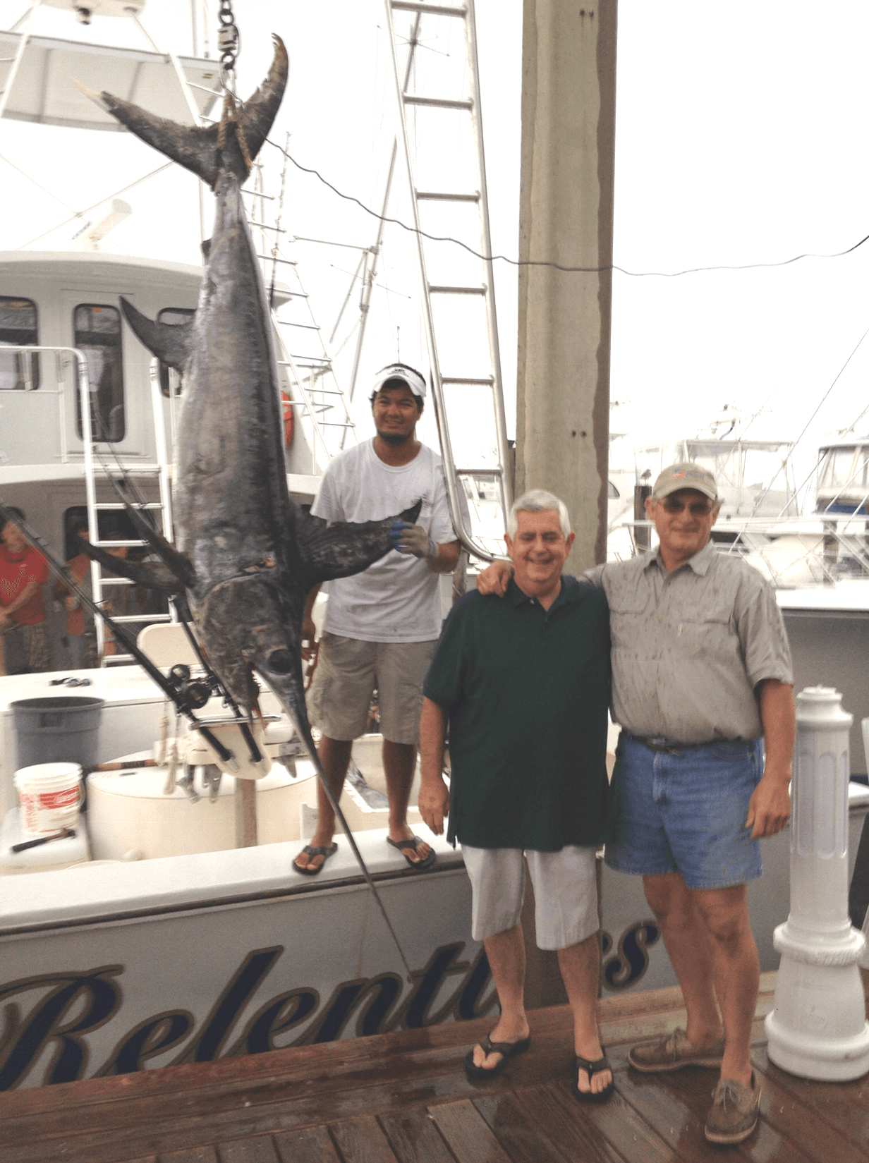 Fishing Destin, FL | Destin Harbor | Charter Boat Relentless | www.charterboatrelentless.com | A Luxury Charter Boat at Everyday Rates | 65' x 20' | Three men are standing next to a large fish (swordfish) on a boat.