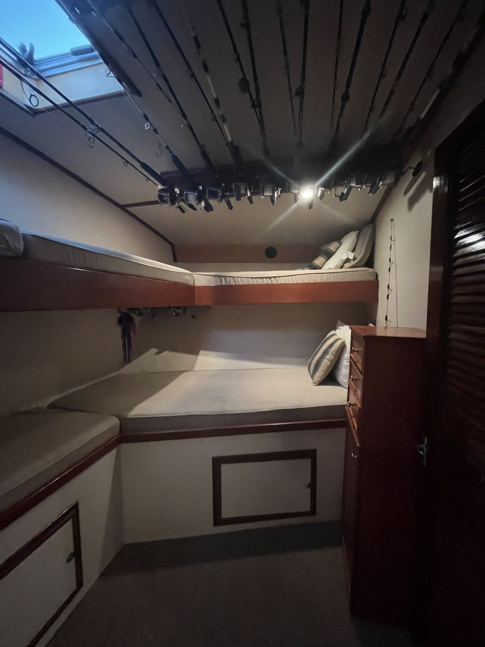 Fishing Destin, FL | Destin Harbor | Charter Boat Relentless | www.charterboatrelentless.com | A Luxury Charter Boat at Everyday Rates | 65' x 20' | A room with bunk beds and fishing rods hanging from the ceiling