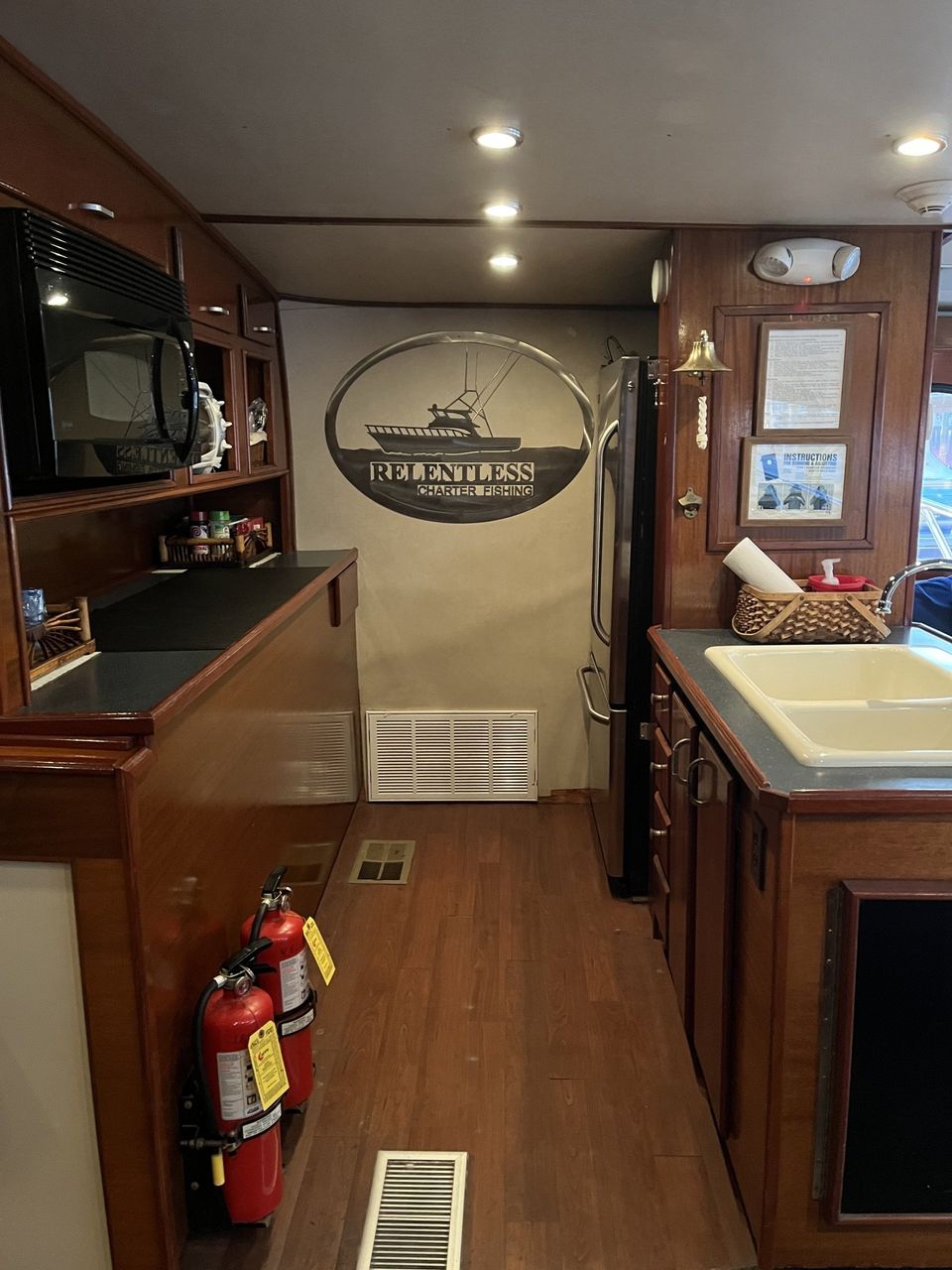 Fishing Destin, FL | Destin Harbor | Charter Boat Relentless | www.charterboatrelentless.com | A Luxury Charter Boat at Everyday Rates | 65' x 20' | A kitchen with a sink , refrigerator , microwave and fire extinguishers.