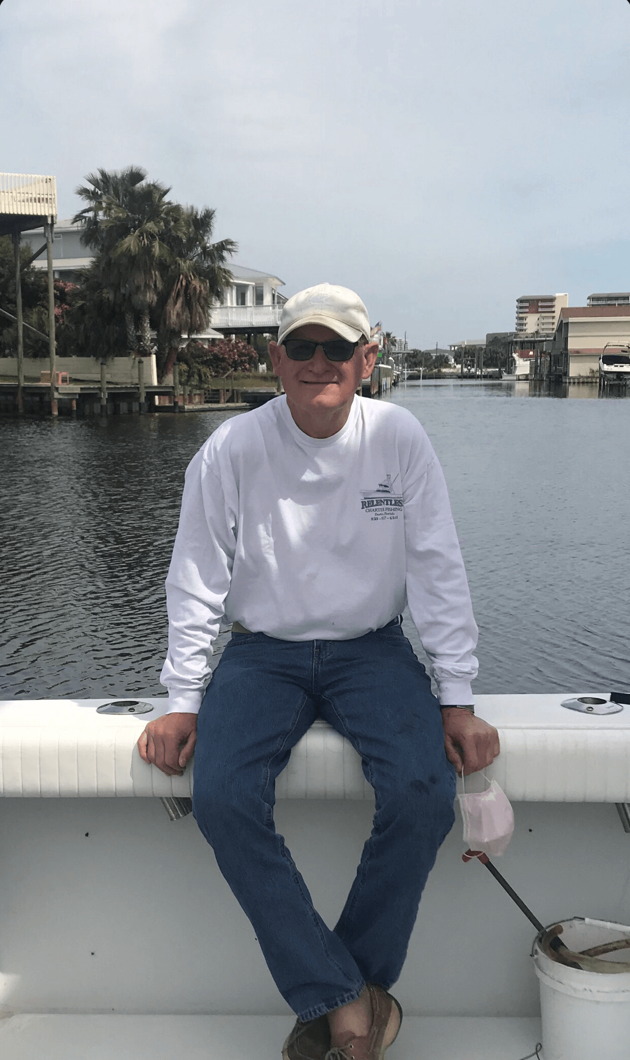A man is sitting on the side of a boat.