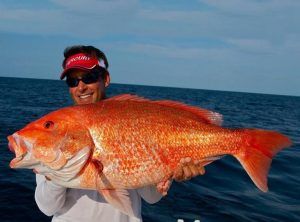 Fishing Destin, FL | Destin Harbor | Charter Boat Relentless | www.charterboatrelentless.com | A Luxury Charter Boat at Everyday Rates | 65' x 20' | A man is holding a large red snapper fish in his hands