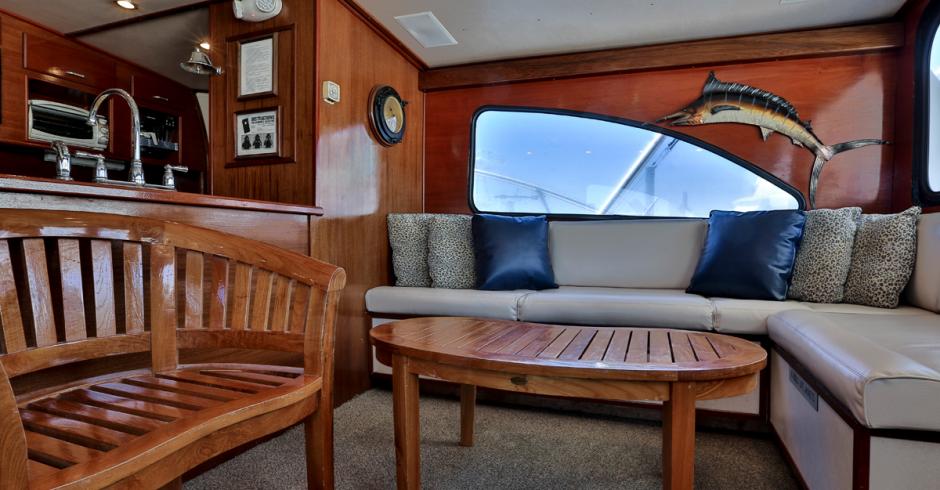 AFishing Destin, FL | Destin Harbor | Charter Boat Relentless | www.charterboatrelentless.com | A Luxury Charter Boat at Everyday Rates | 65' x 20' | Living room, main salon, on the Relentless with a couch and a table