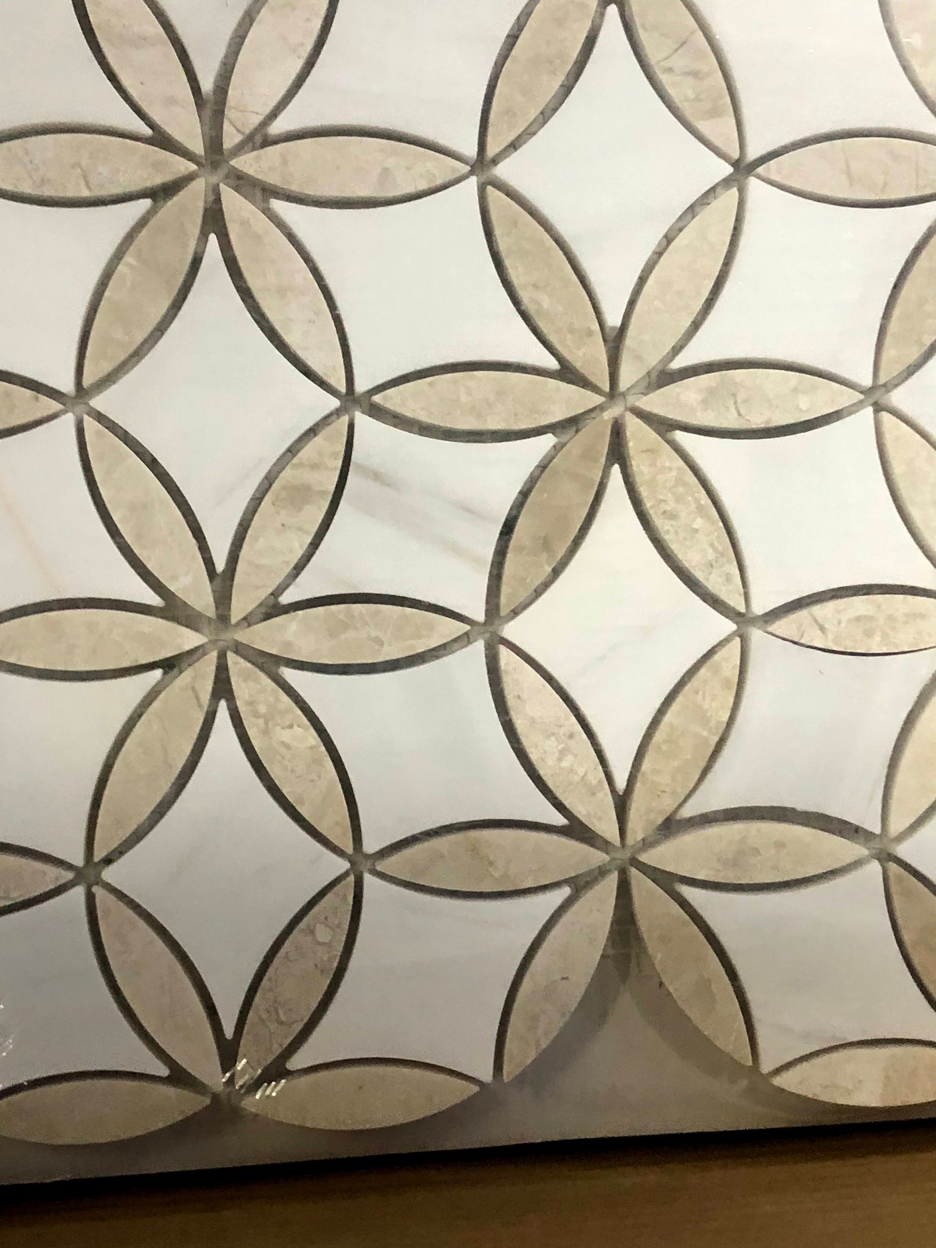 Geometric floral wallpaper pattern in beige, taupe, and cream with interlocking petal shapes