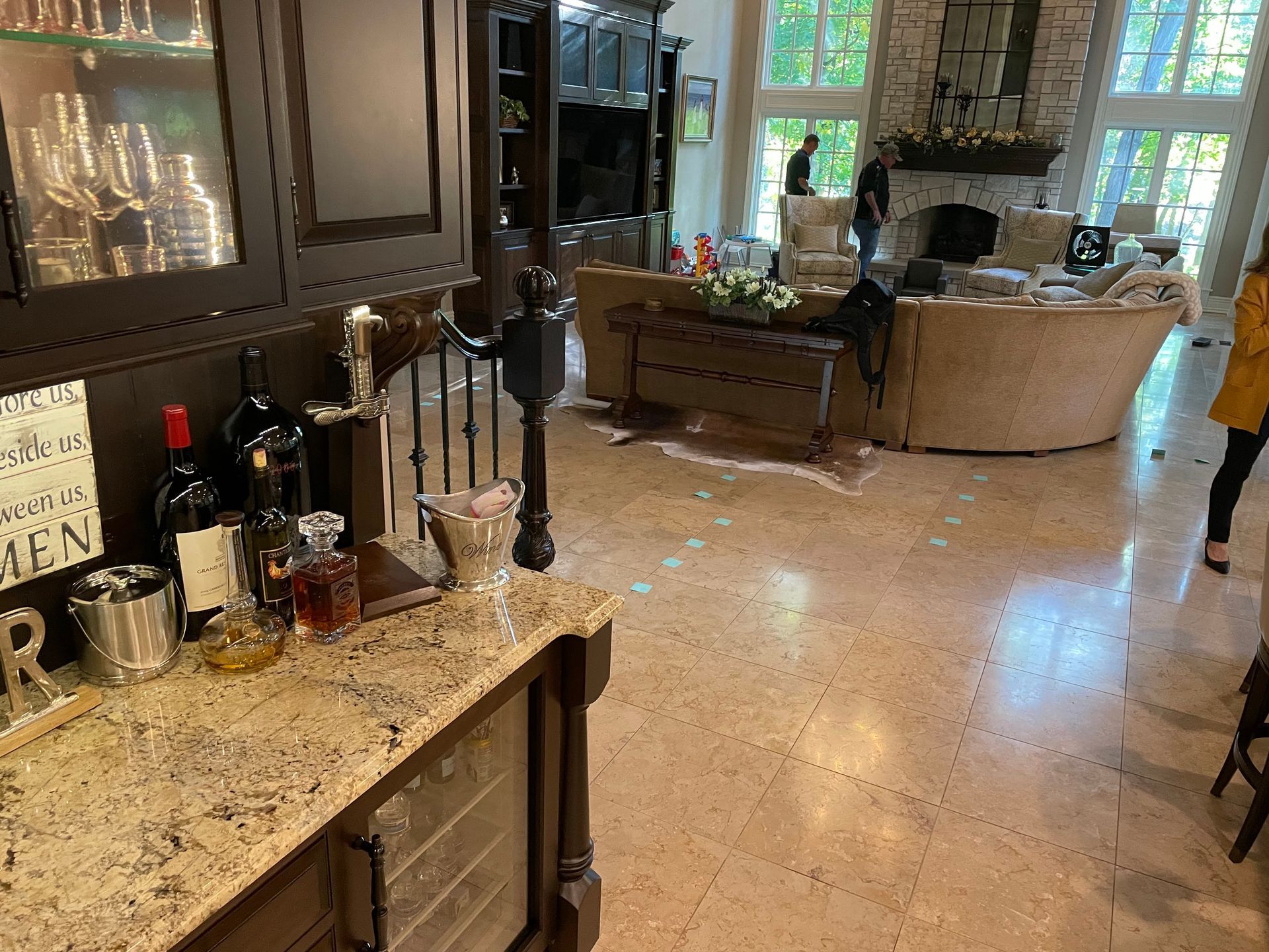 Modern kitchen with granite island, dark cabinets, and a living room visible in the background.
