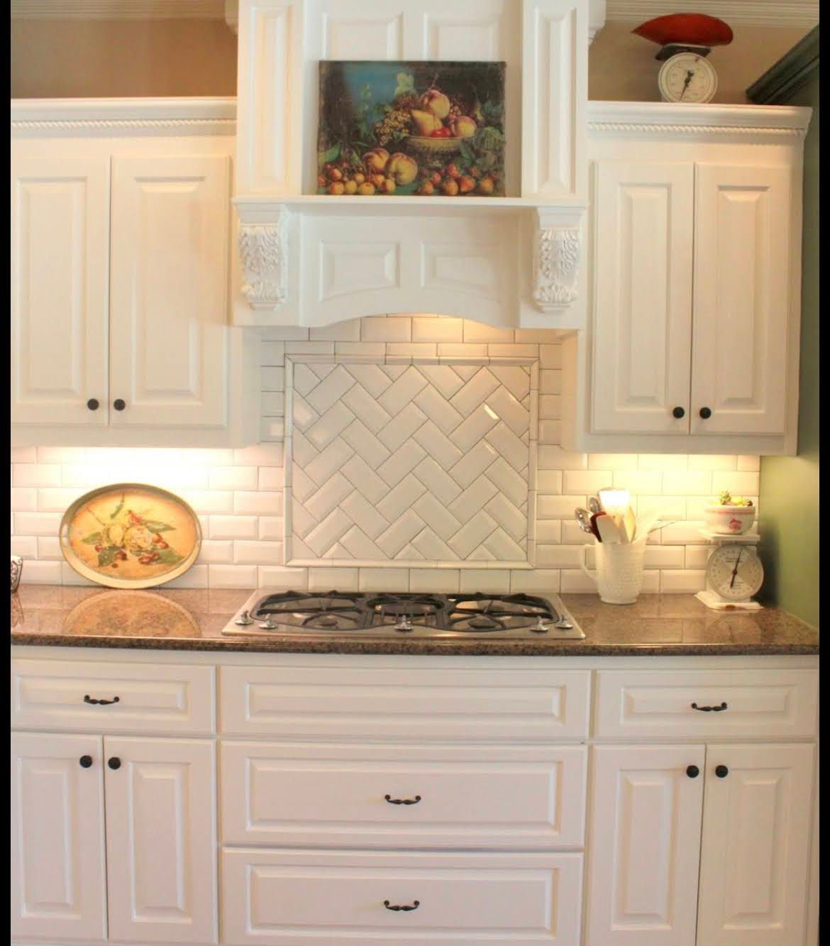 White kitchen with ornate cabinets, tiled backsplash, stove, and warm under-cabinet lighting