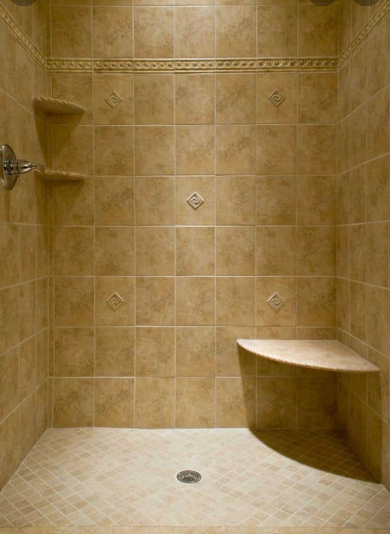 Tan tiled walk-in shower with a built-in corner bench and chrome showerhead.