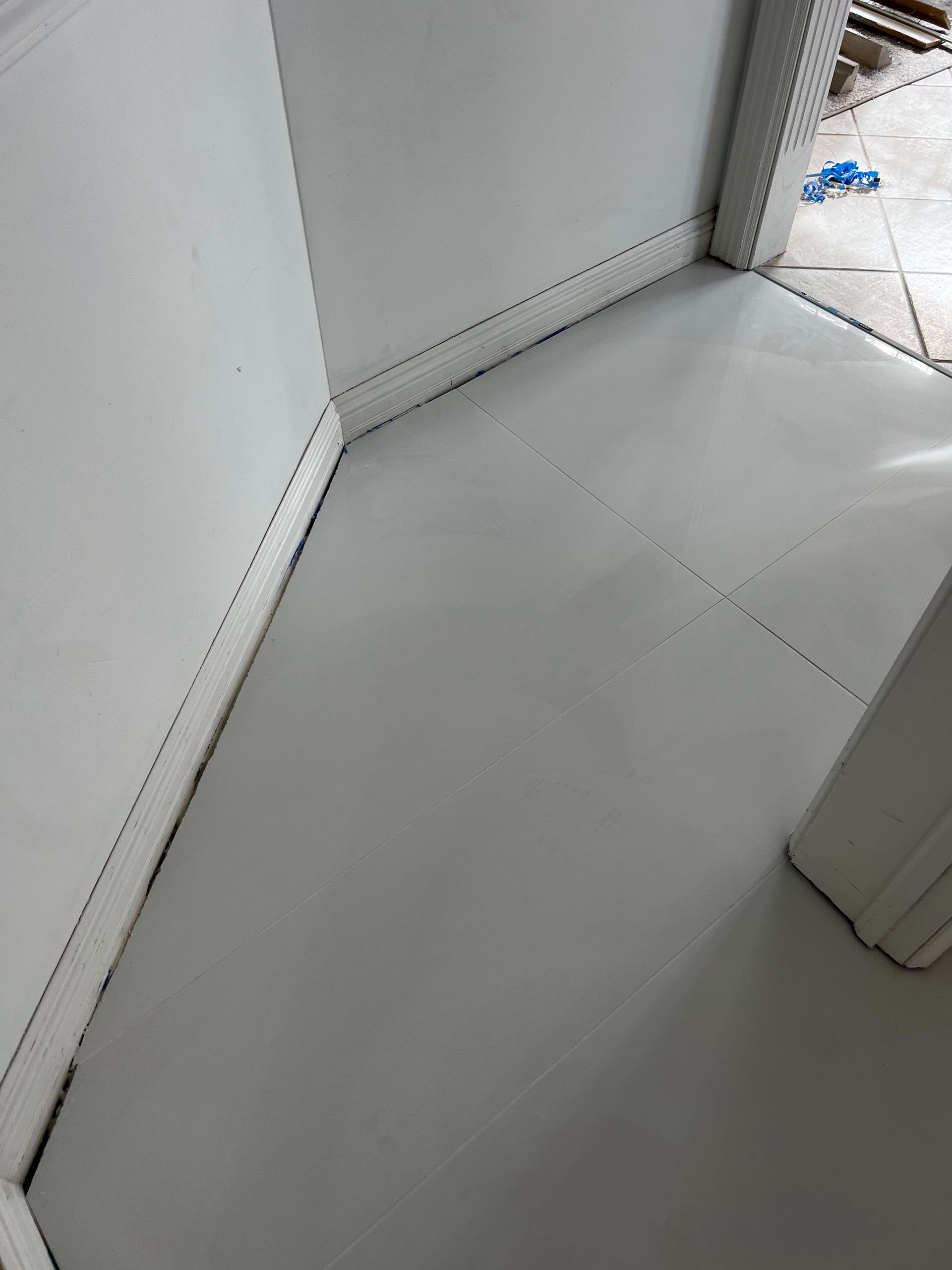 White padded interior corner with stitched seams and a small glimpse of blue item outside the opening