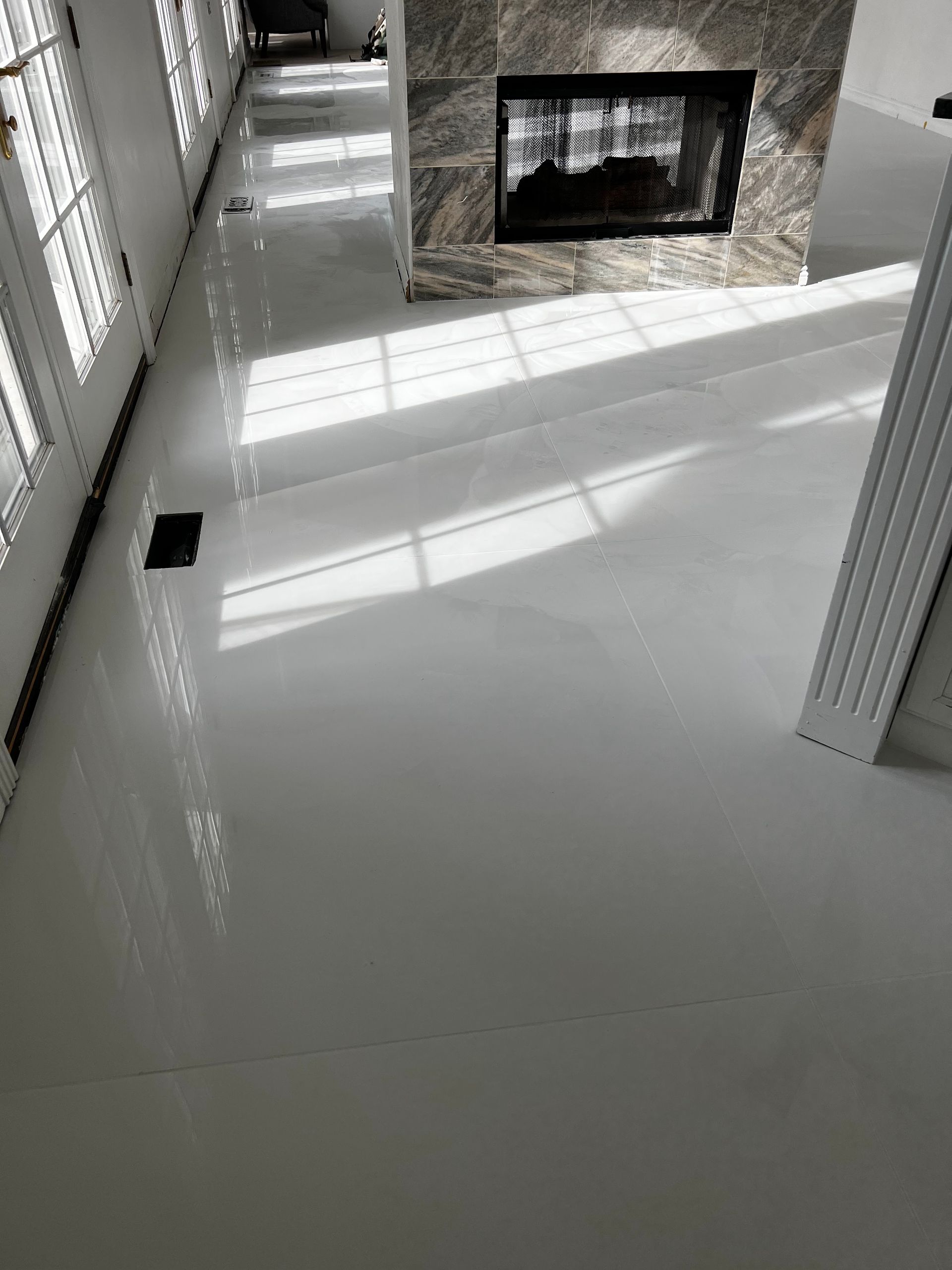 Bright white living room floor with sunlight stripes and a built-in fireplace.