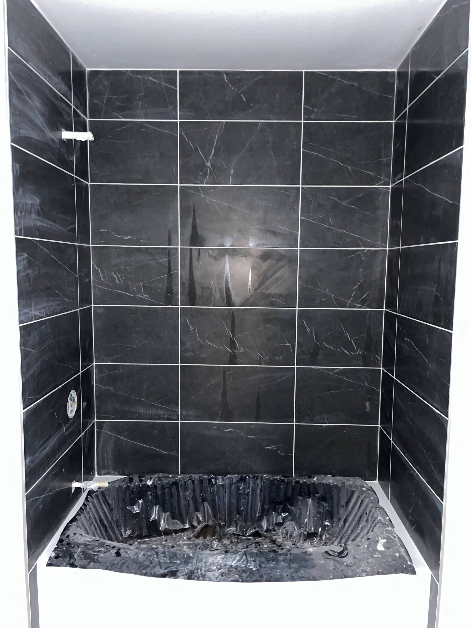 Black-tiled fireplace with a white mantel and a dark ash-covered firebox.