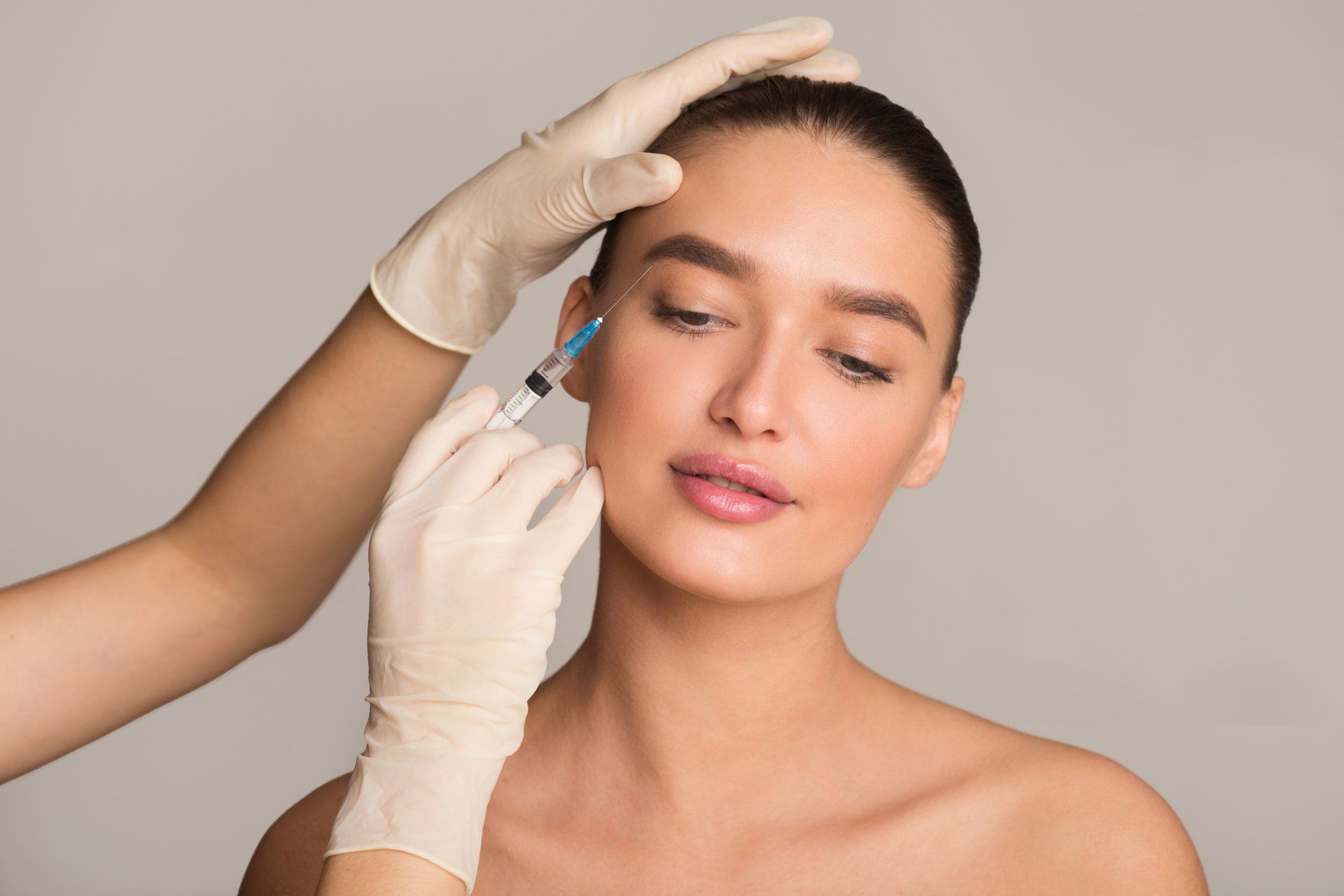 woman receiving an injection under her eyebrow