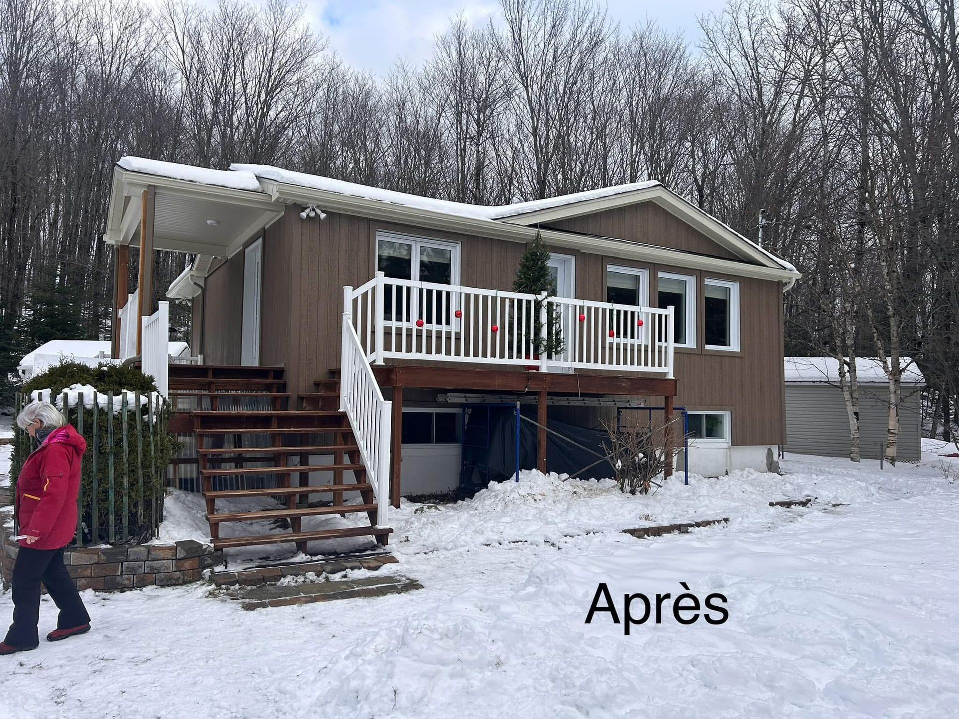 Une maison brune avec une terrasse et une cour enneigée, portant l'inscription « Après », avec une personne marchant au premier plan.