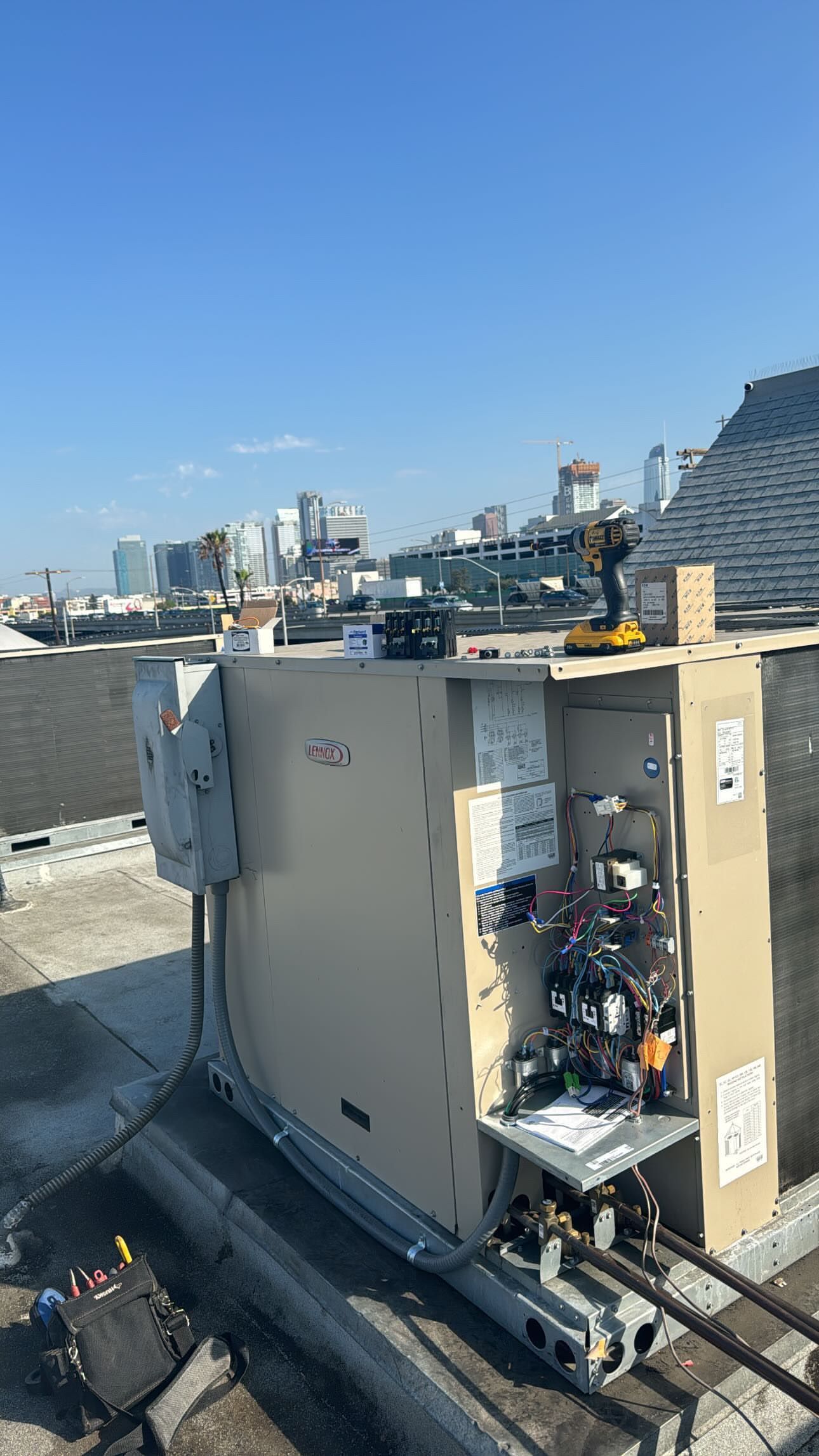 Technician testing an outdoor air-conditioning unit with a multimeter