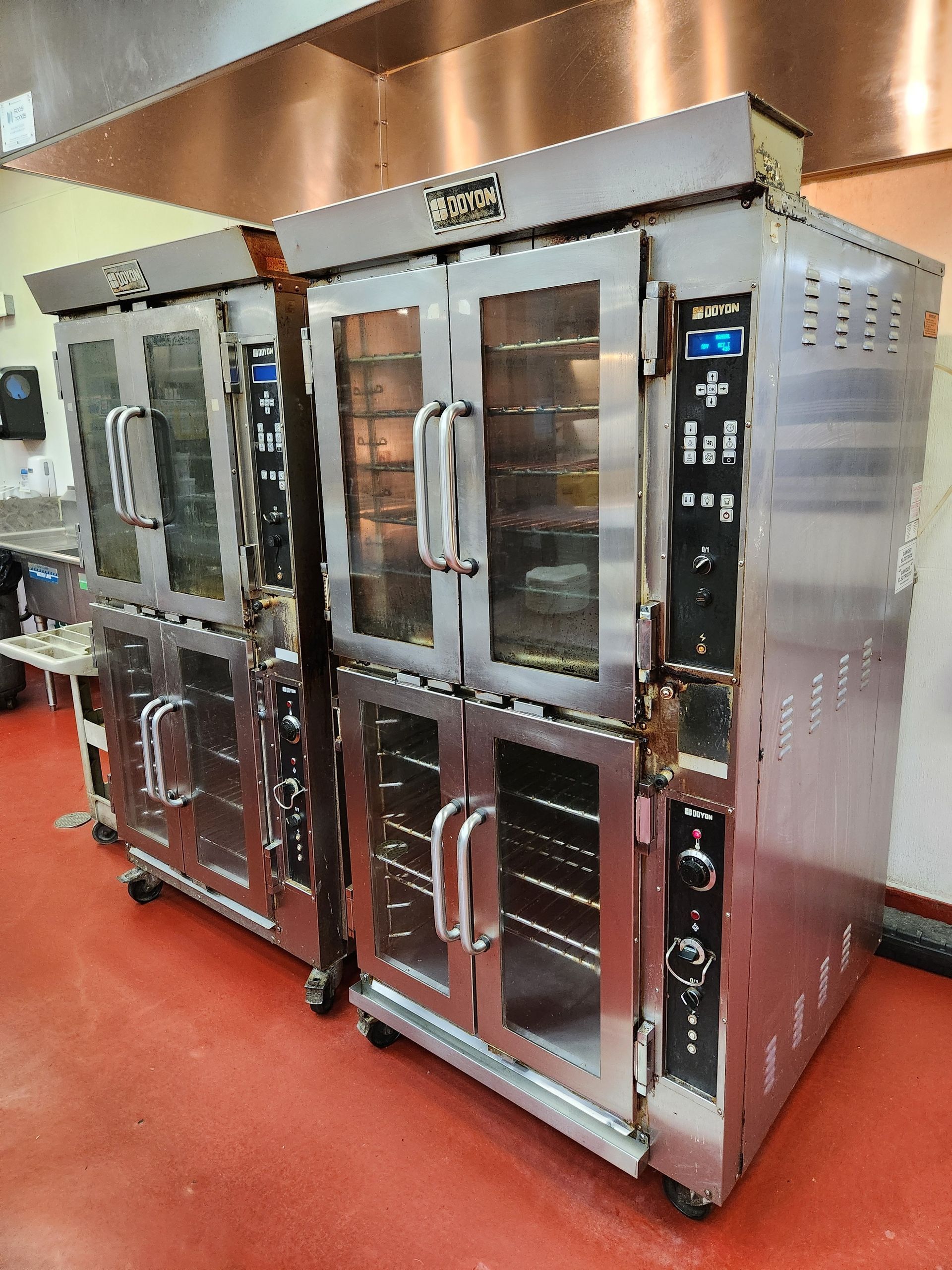 Technician repairing wiring on an industrial oven in a commercial kitchen