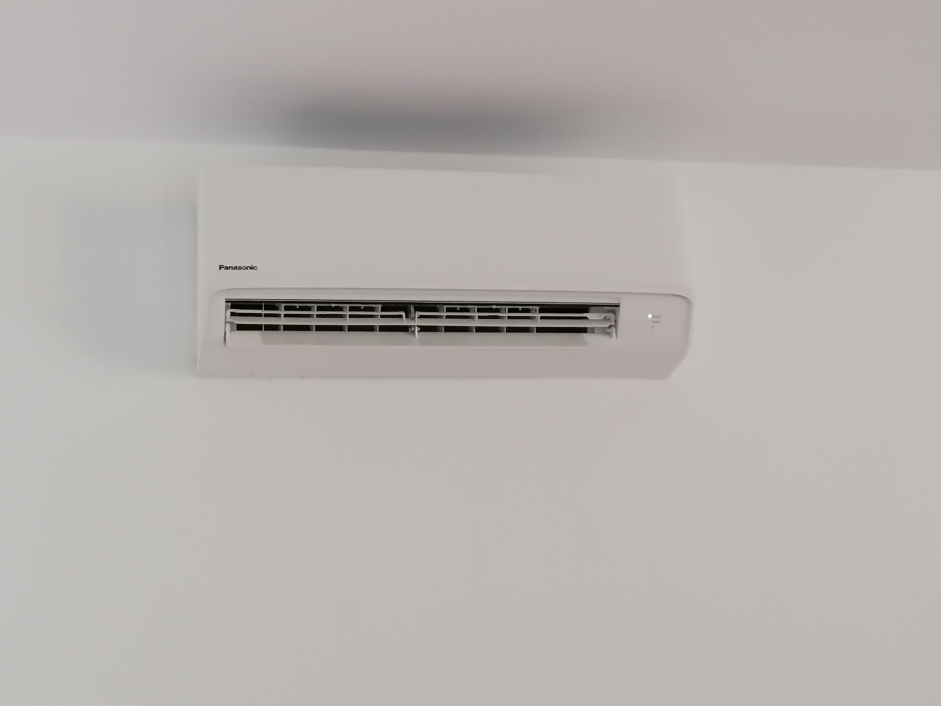 Weiße Klimaanlage an einer weißen Wand.