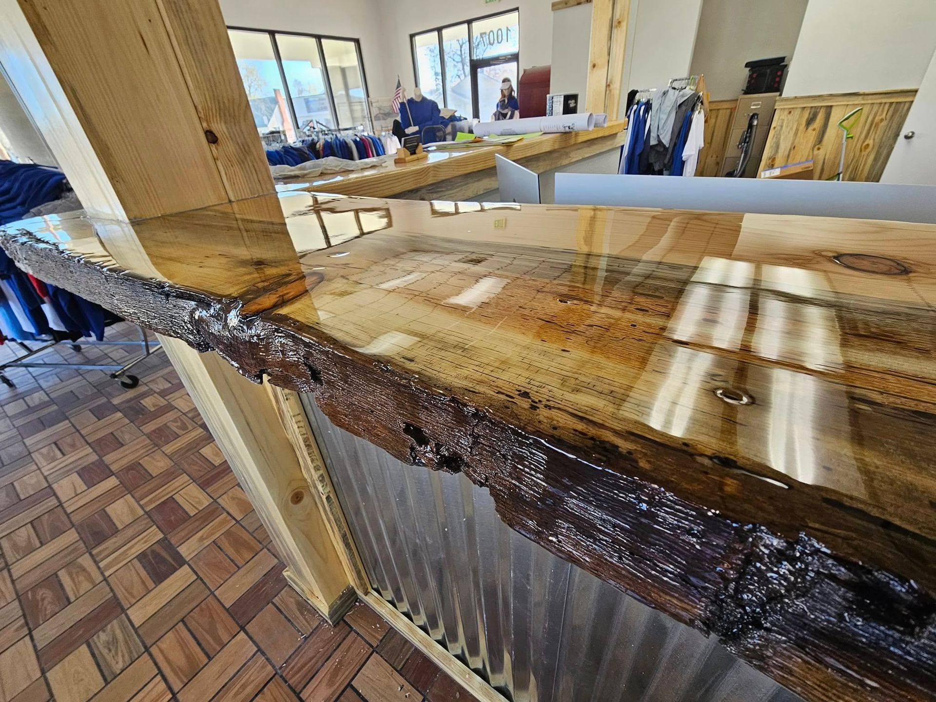 Rustic wooden bar counter with a rough live-edge finish in a bright room with windows