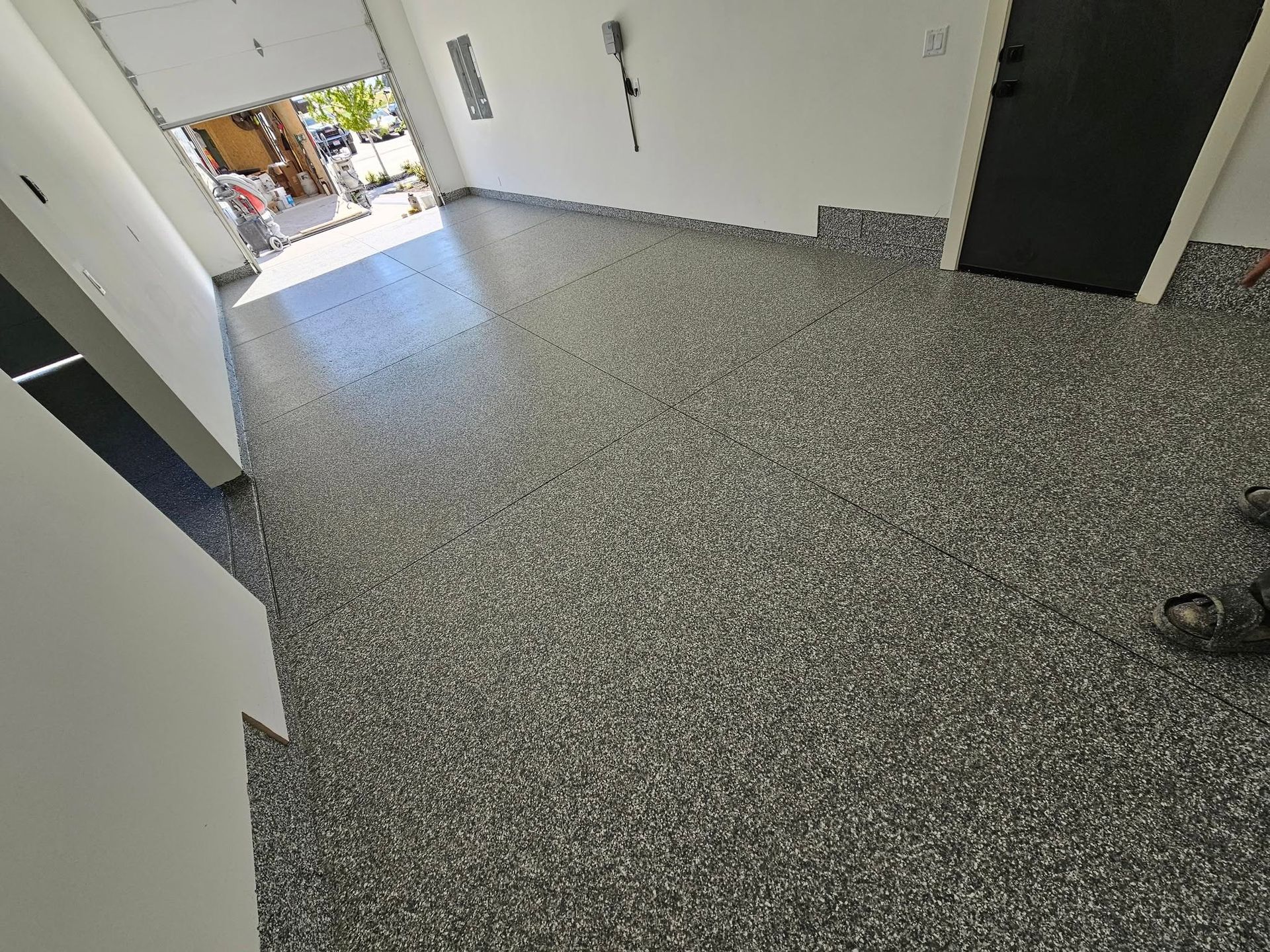 Empty tiled hallway with open doorway and a shoe visible on the right