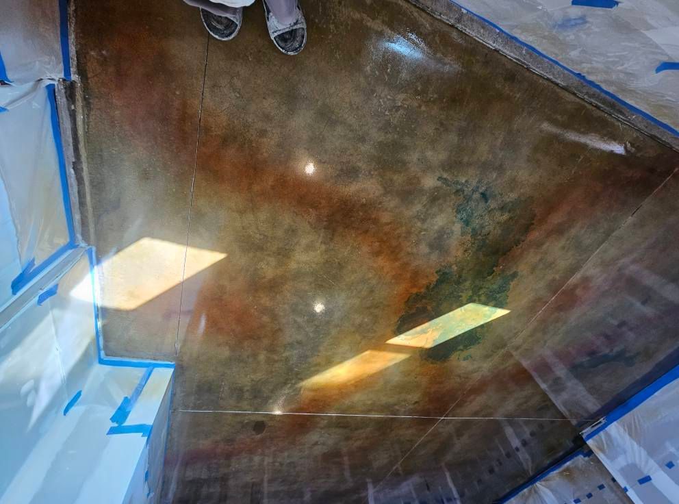Interior view of a large concrete shaft under construction, with blue tape and light reflections on the walls.