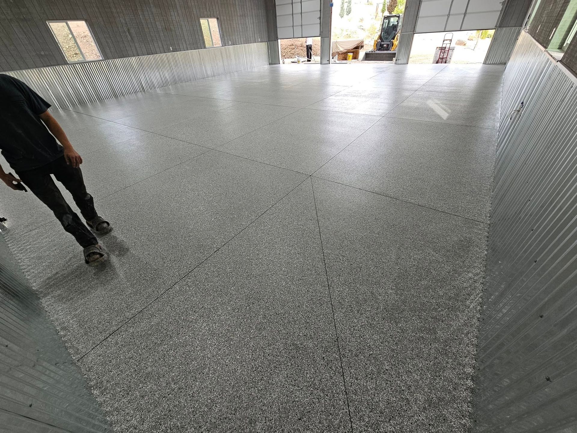 Indoor granite floor with a person standing at the left edge near a bright entrance.
