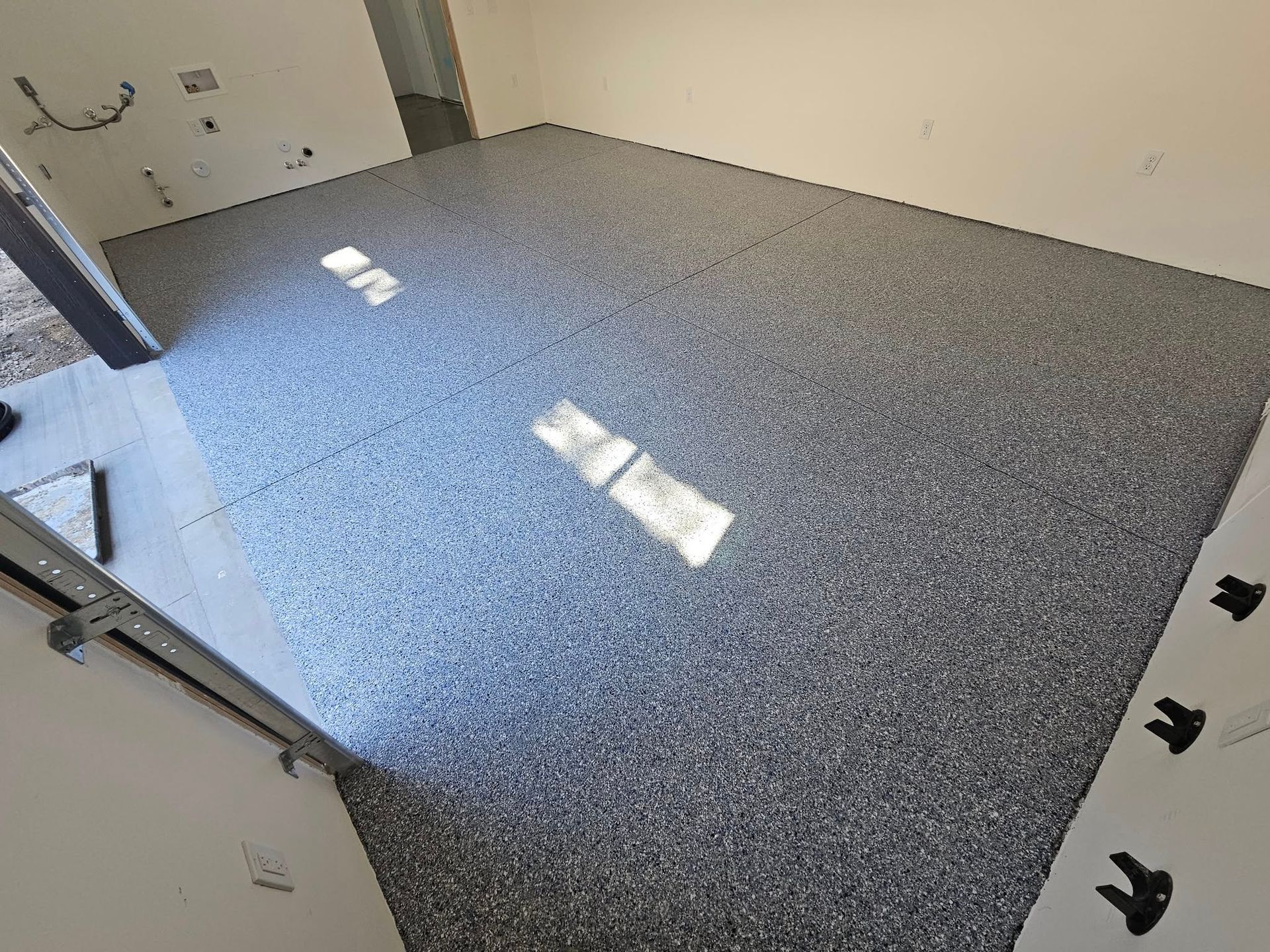 Empty carpeted room with white walls and sunlight patches on the floor