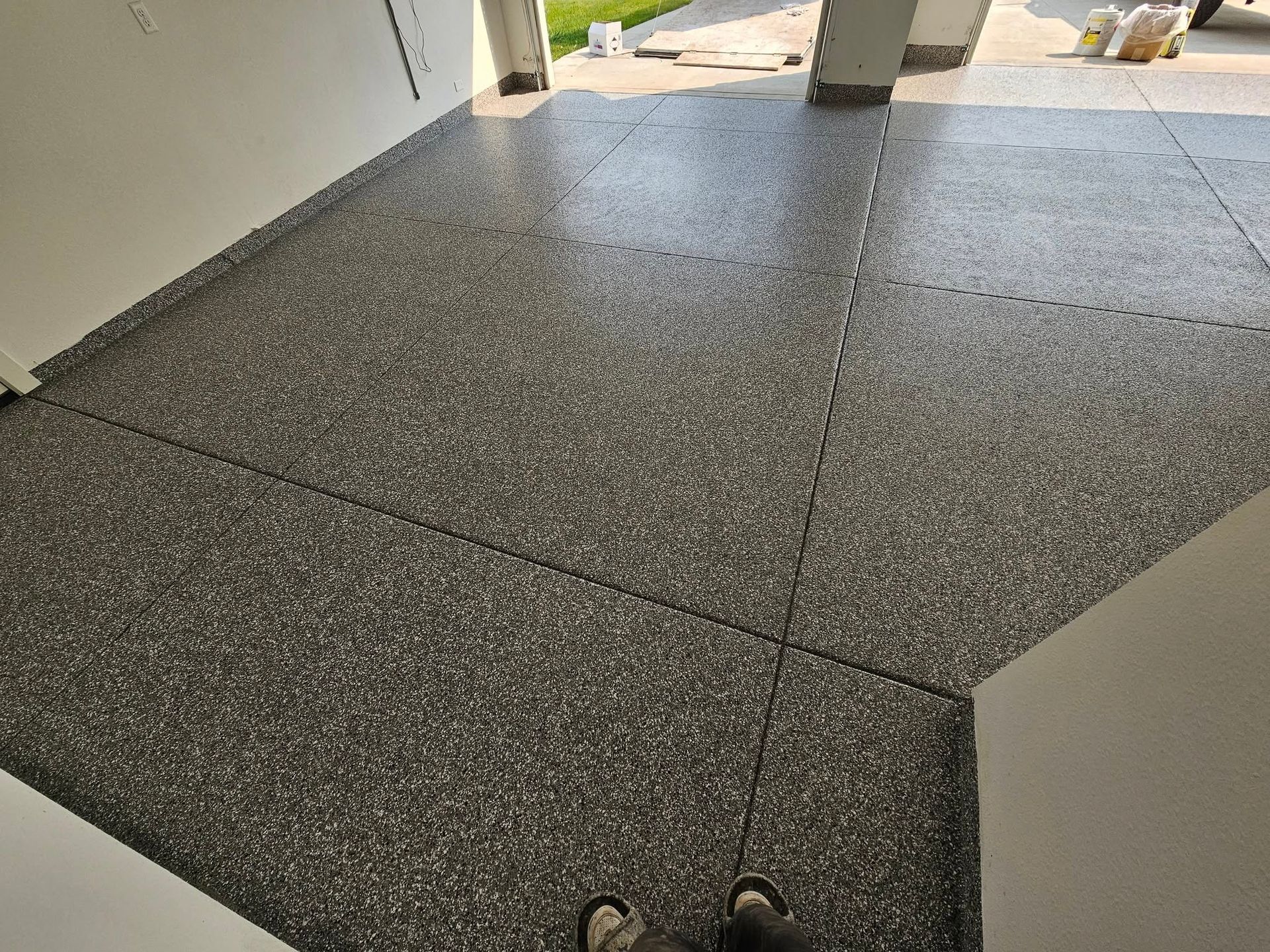 Gray speckled tile floor in a hallway, viewed from above