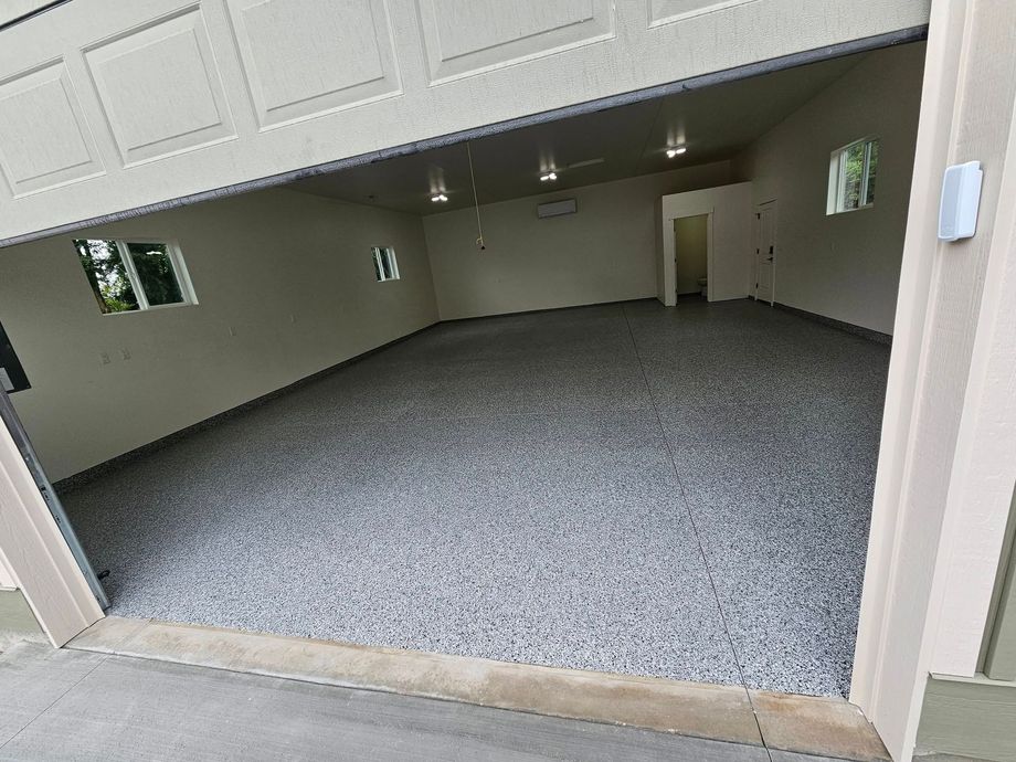 Empty garage with gray carpet and white walls, viewed from the open doorway