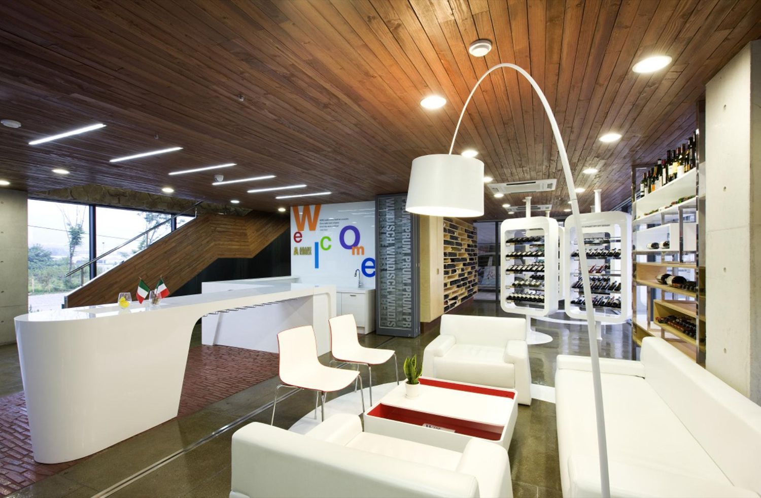 Modern living room with white furniture, wood ceiling, arched floor lamp, and colorful wall art