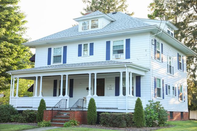 A large white house with a garage and a balcony.
