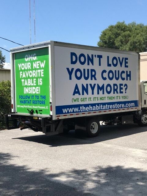 Habitat for Humanity truck with green and white signs: “Don’t love your couch anymore?”